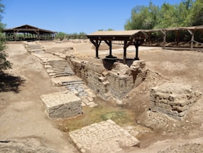 A very old structure in the middle of a dirt field