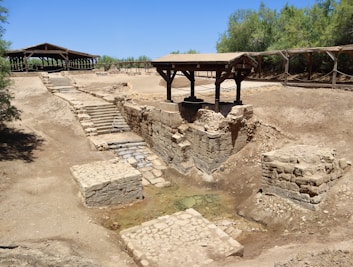 A very old structure in the middle of a dirt field