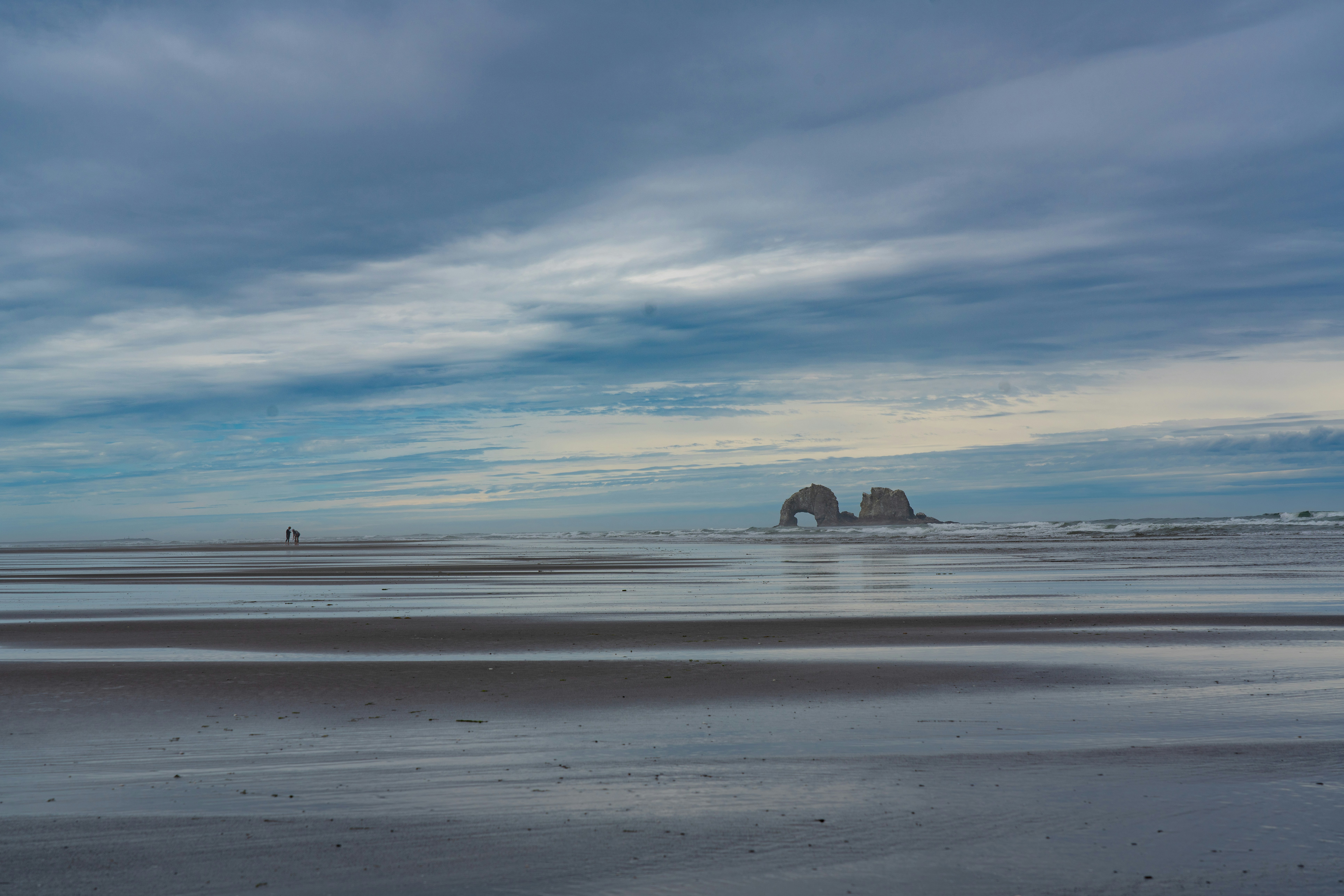 A blurry photo of a beach with a rock formation in the distance