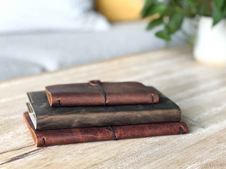 Carnets reliés posés sur une table en bois clair