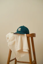 A baseball cap sitting on top of a wooden chair