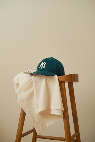 A baseball cap sitting on top of a wooden chair