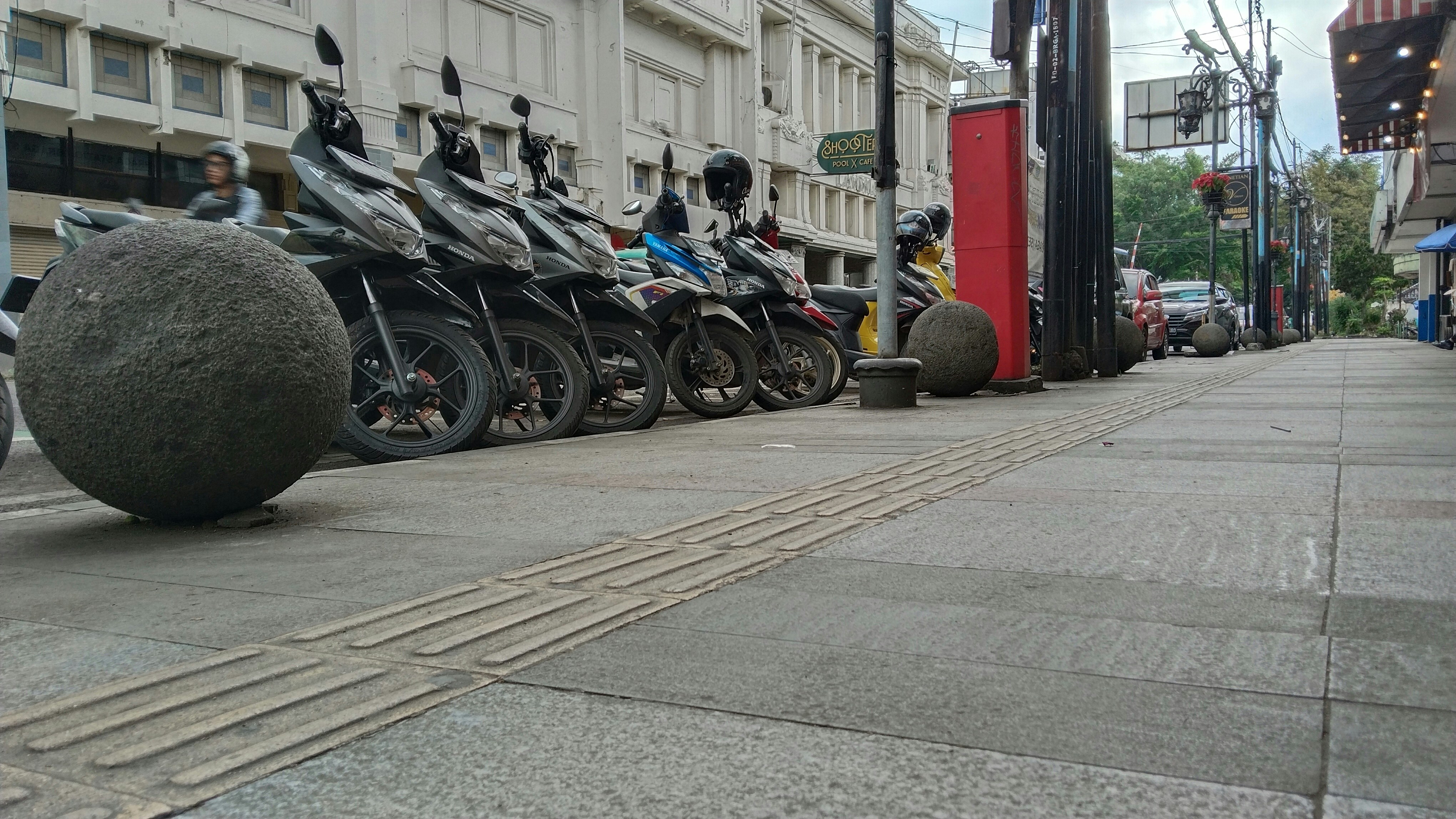 A row of motorbikes parked on the side of the road