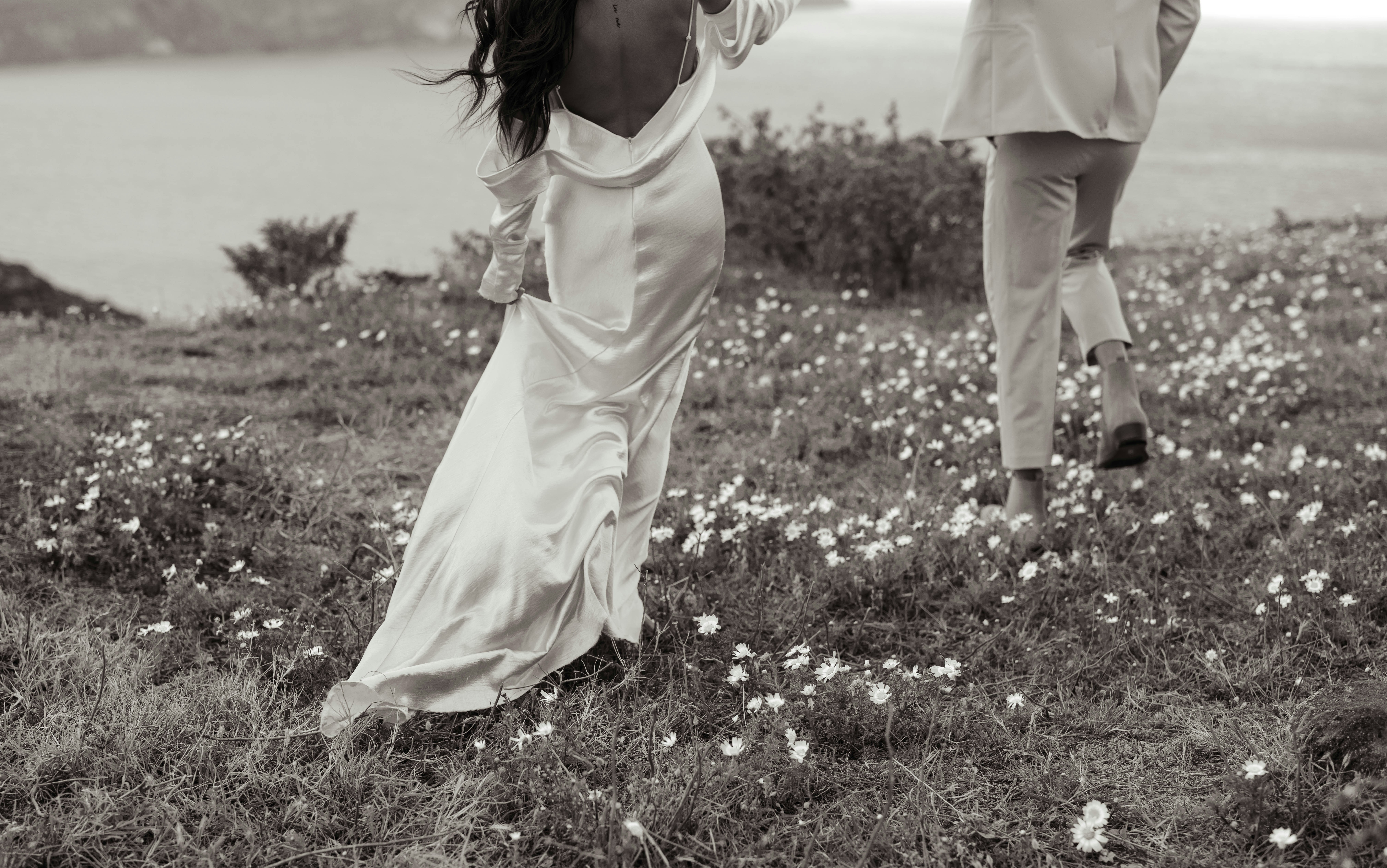 A couple of women walking across a lush green field