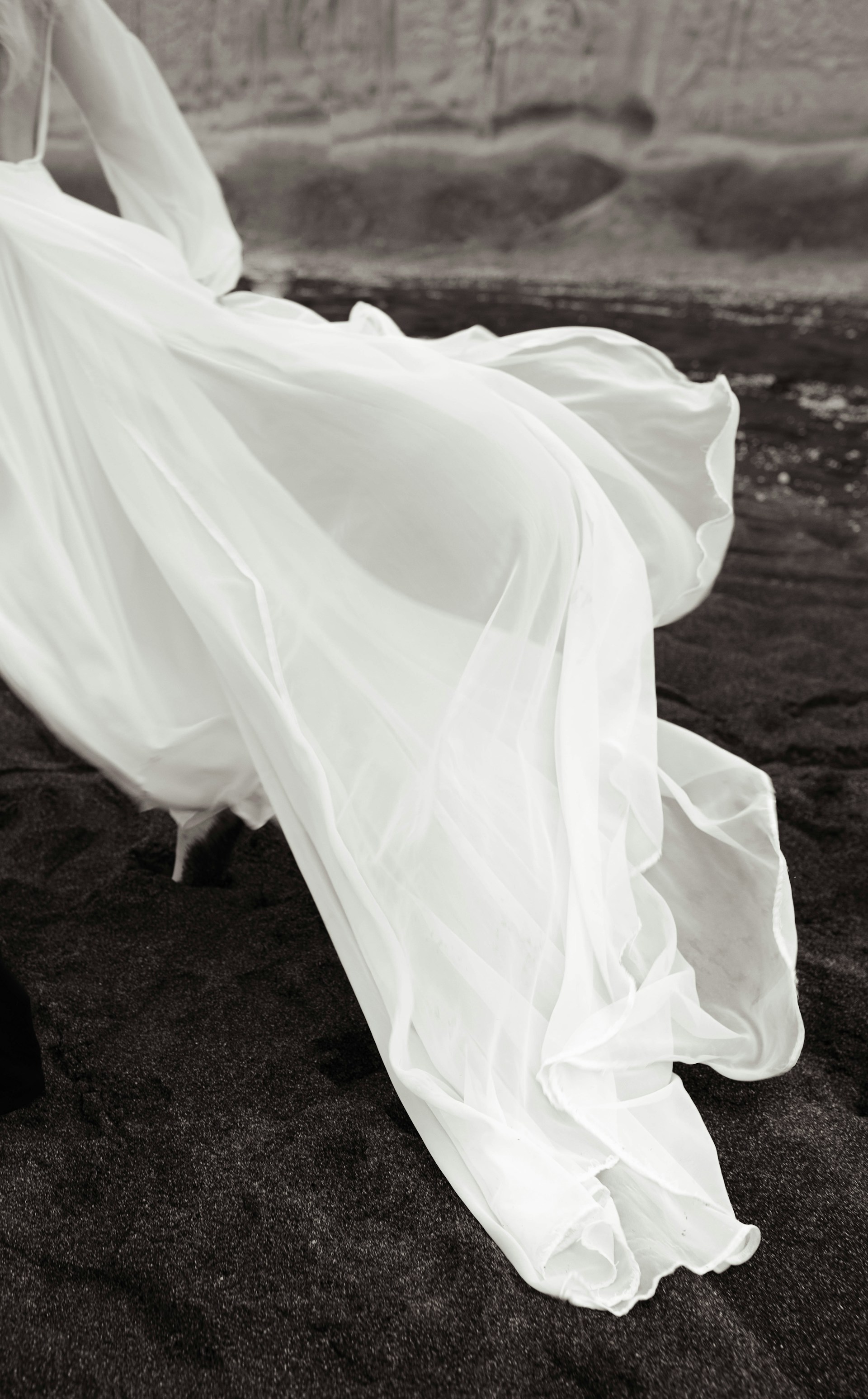 A woman in a long white dress on a beach