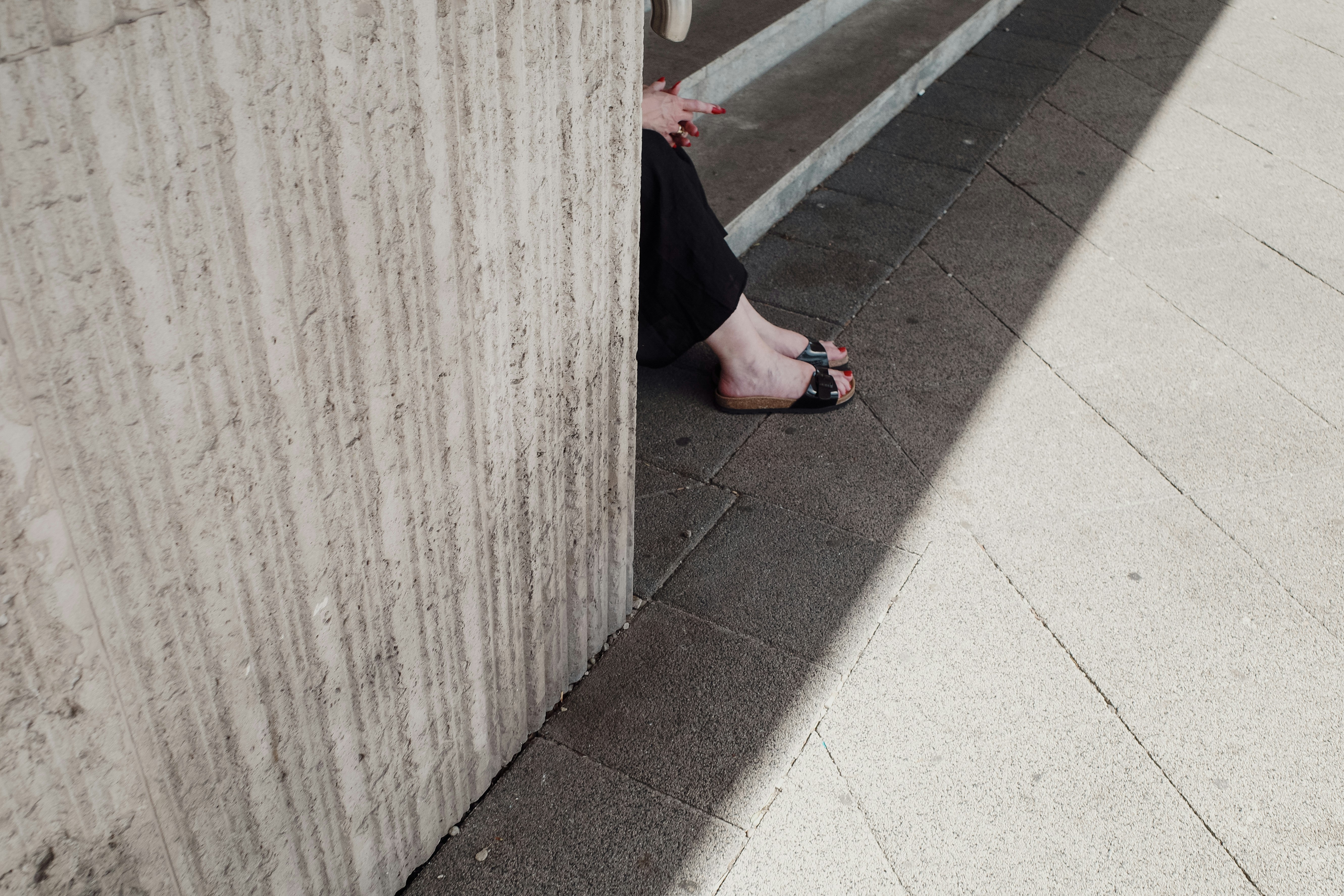 A woman leaning against a wall on her cell phone