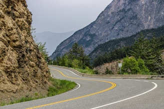 A curved road with a mountain in the background