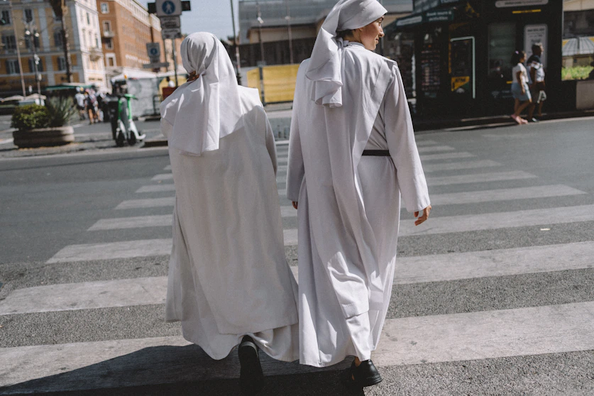 A couple of people walking across a street