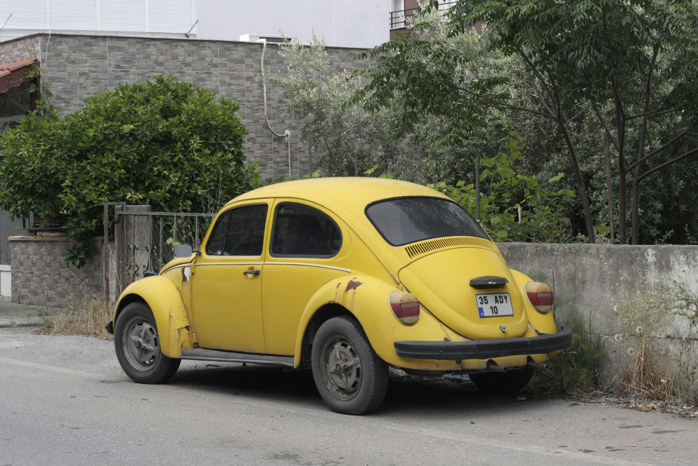 A yellow car parked on the side of the road