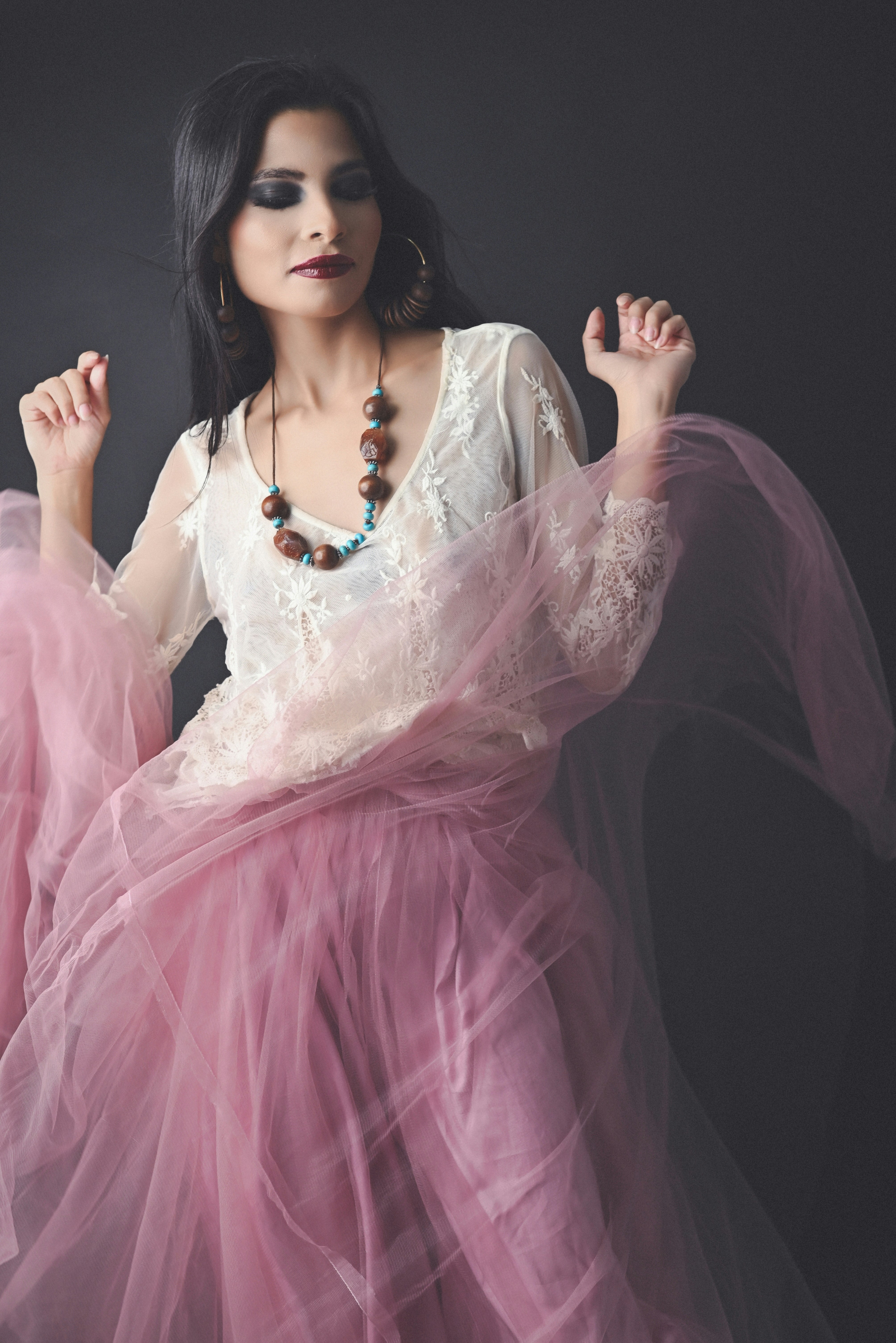 A woman in a pink dress is posing for a picture