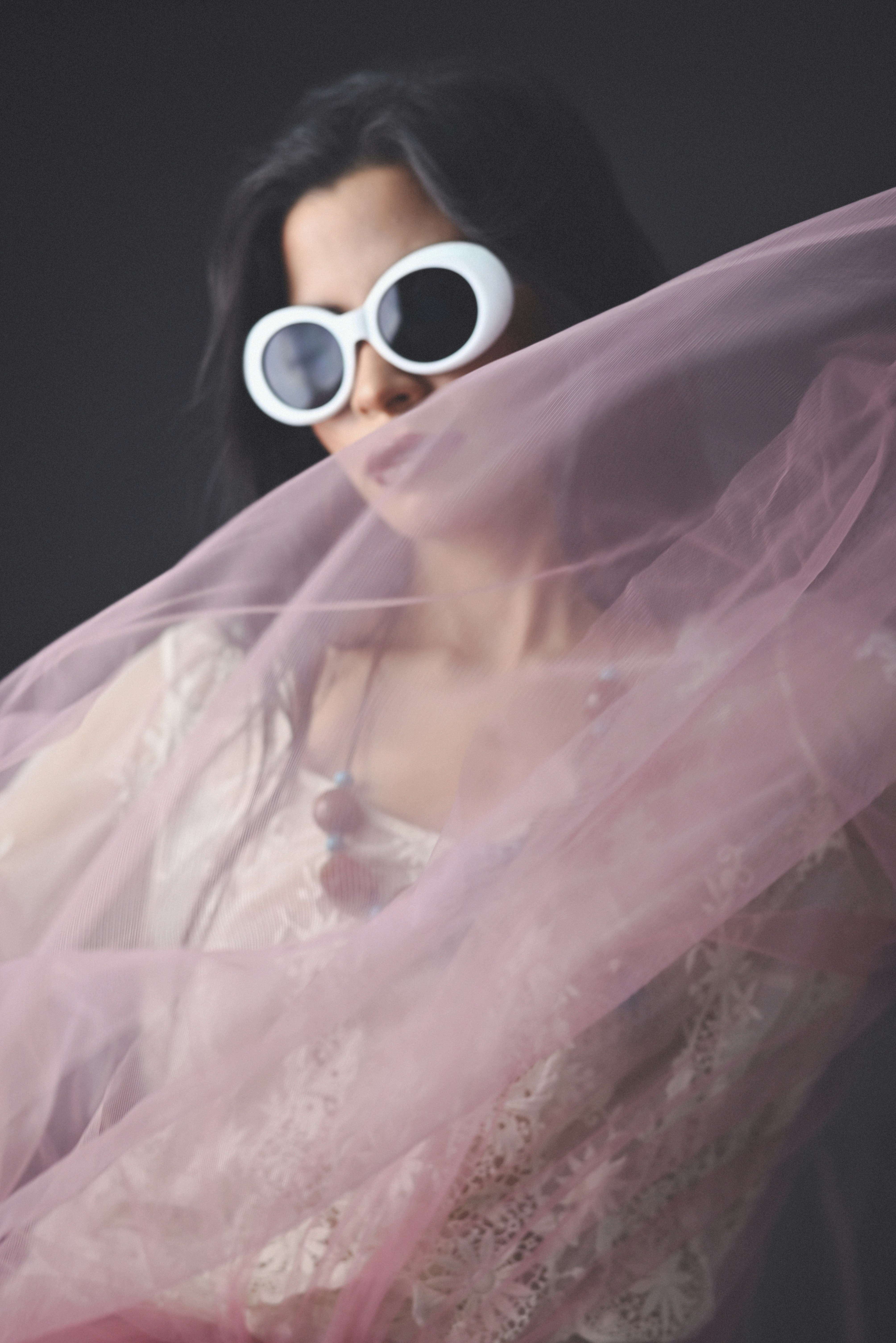 A woman wearing sunglasses and a pink dress