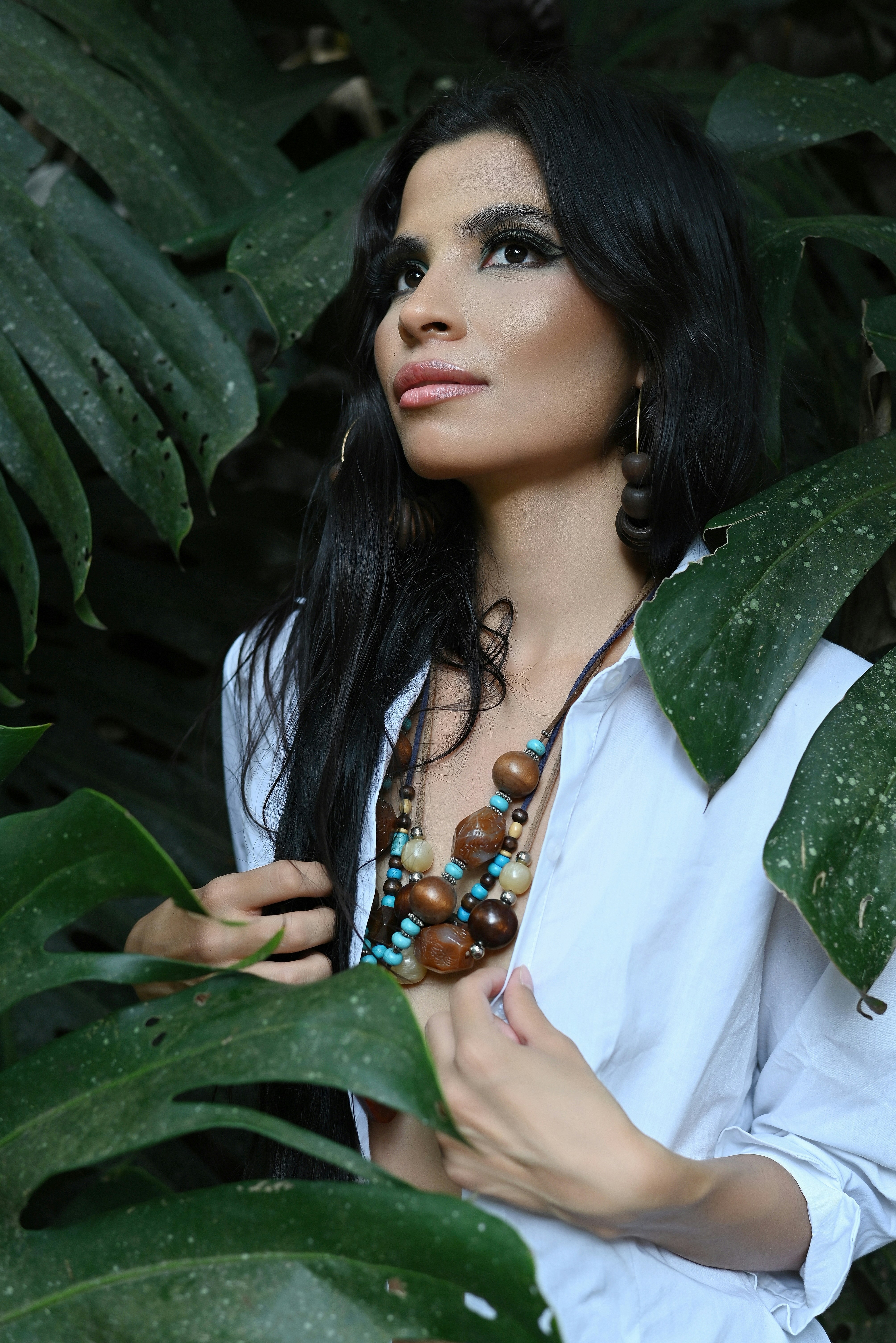 A woman wearing a white shirt and a necklace