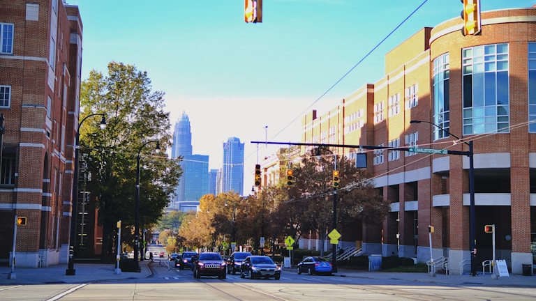 A city street filled with traffic next to tall buildings