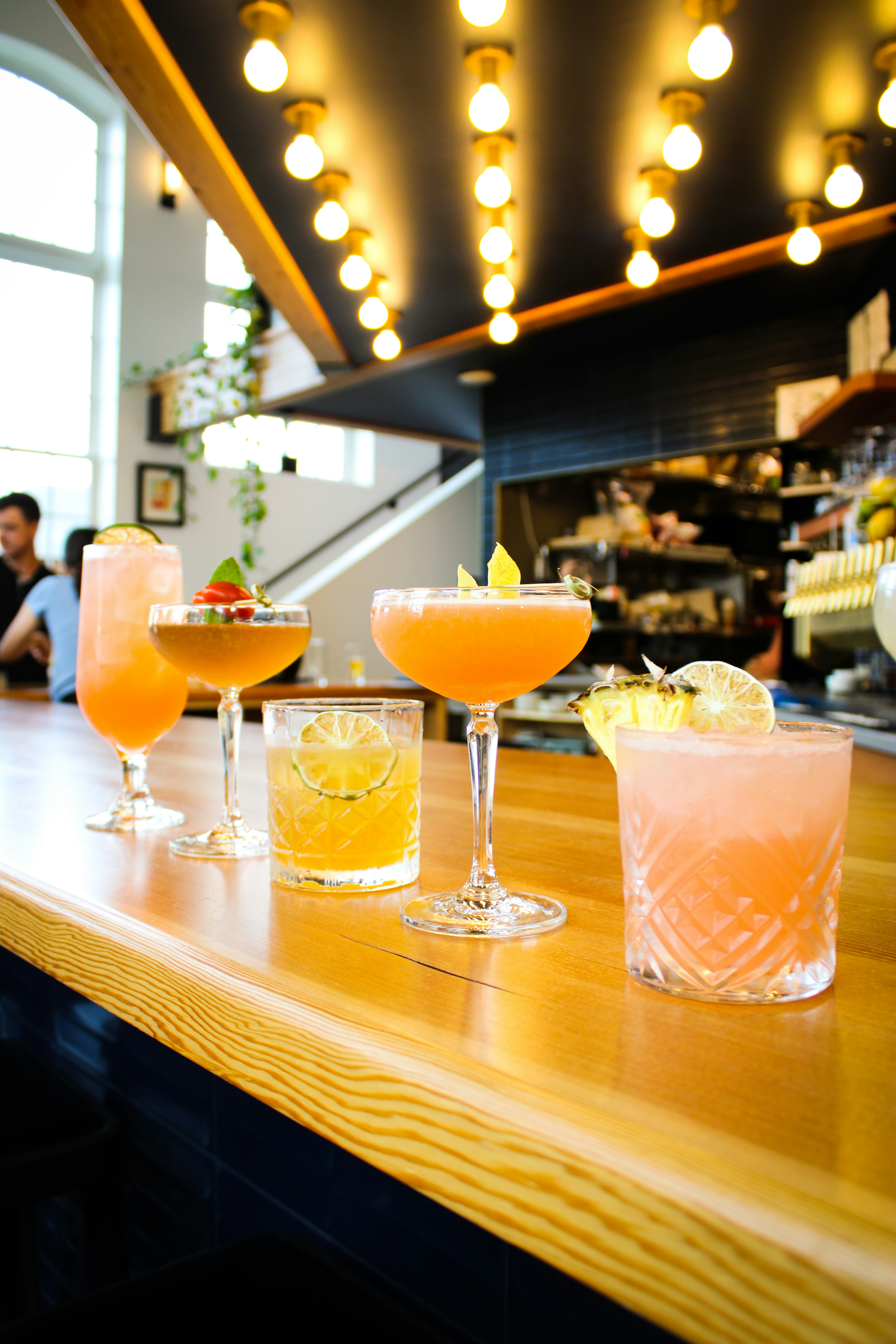 A group of drinks sitting on top of a wooden bar