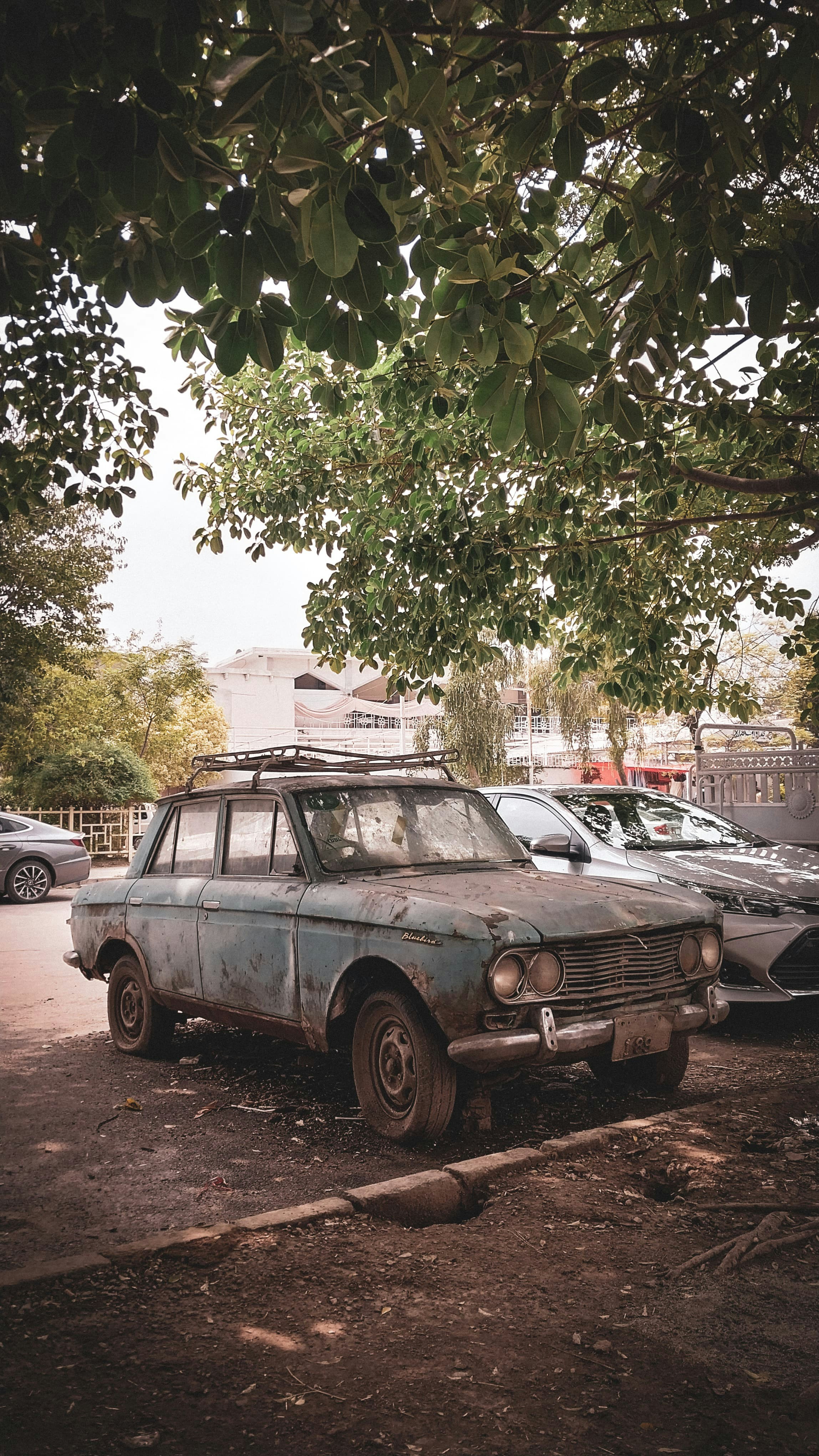 Ein altes Auto wird auf einem Parkplatz abgestellt