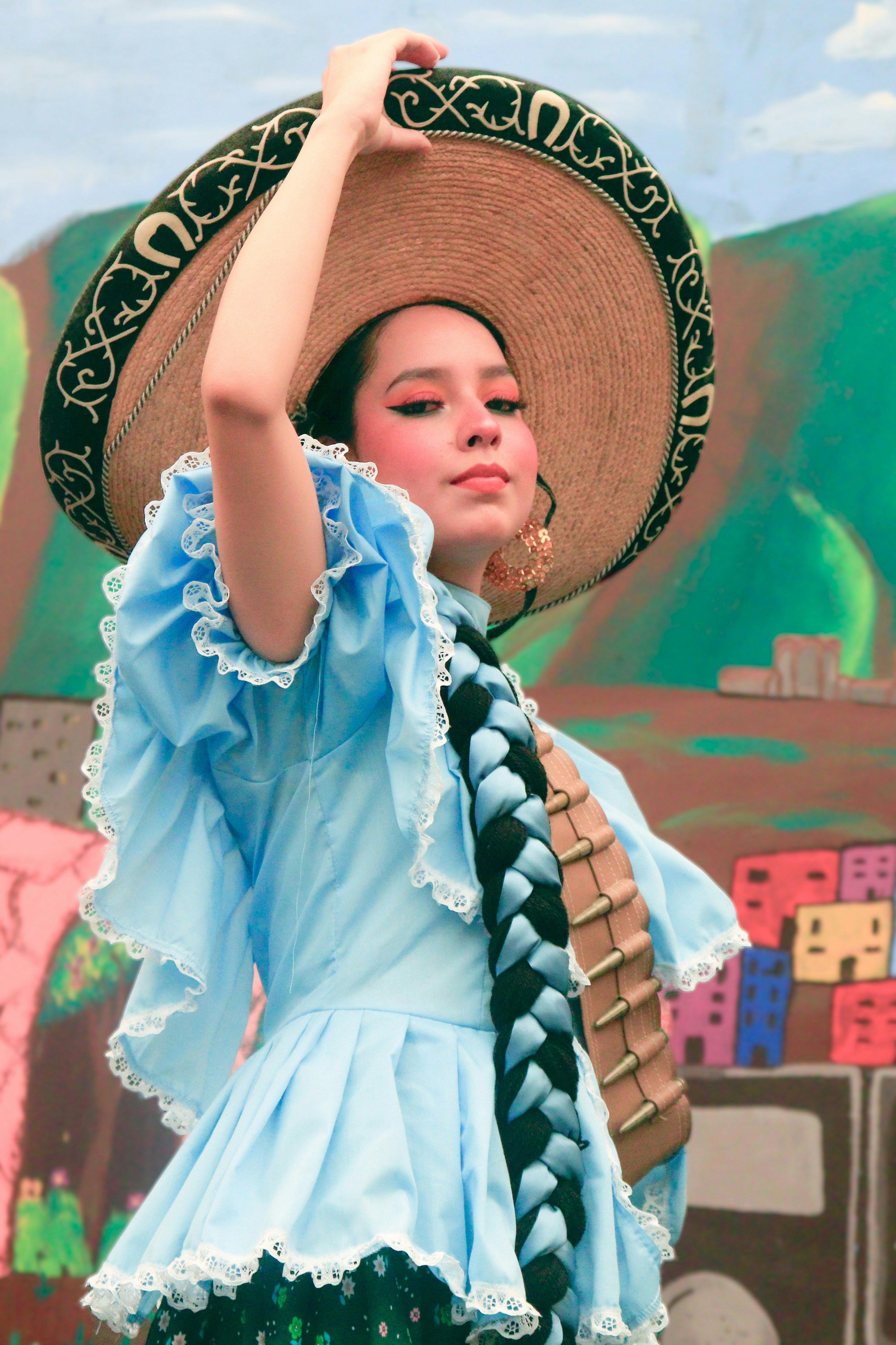 A woman in a blue dress and a straw hat