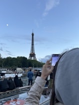 A woman taking a picture of the eiffel tower