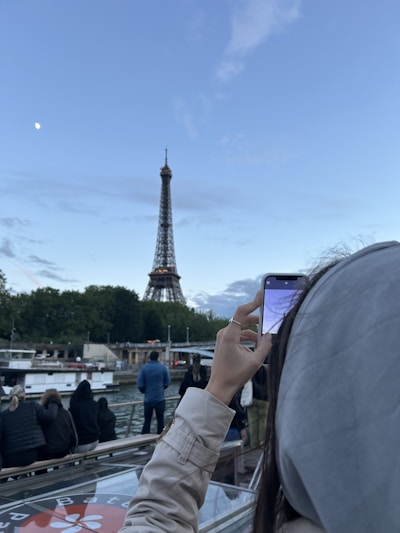 A woman taking a picture of the eiffel tower