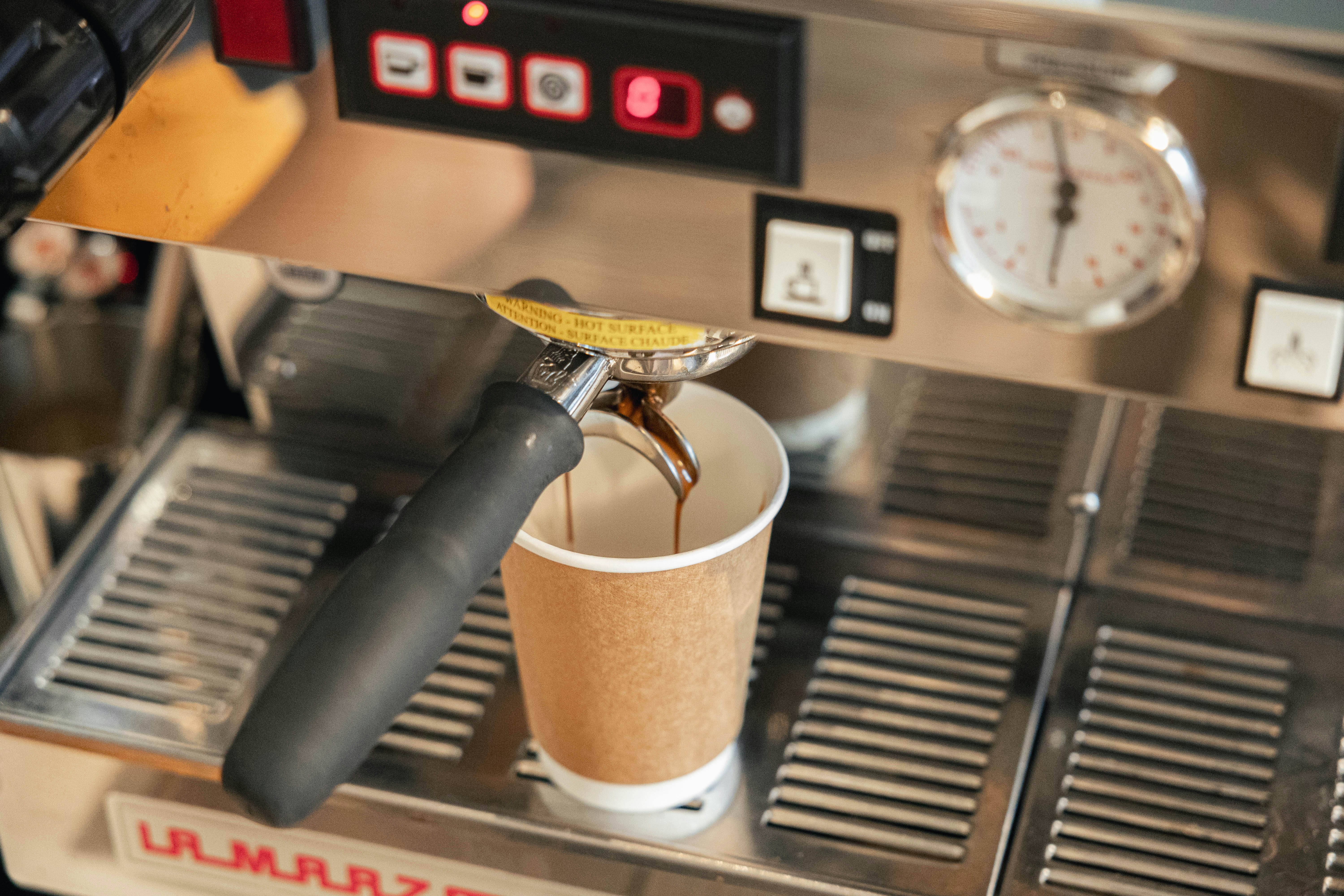 A coffee machine with a cup of coffee on top of it