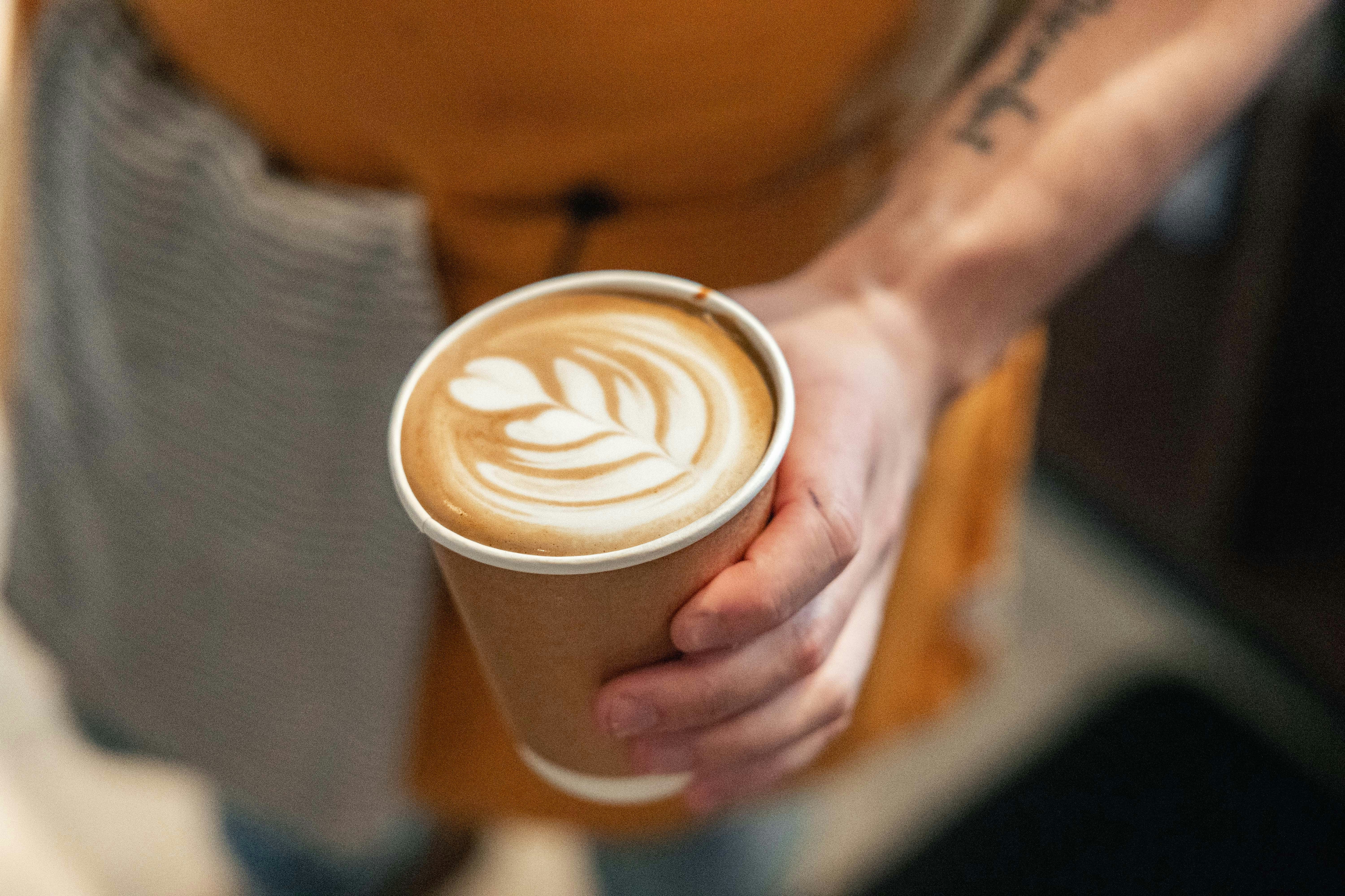 A person holding a cup of coffee in their hand
