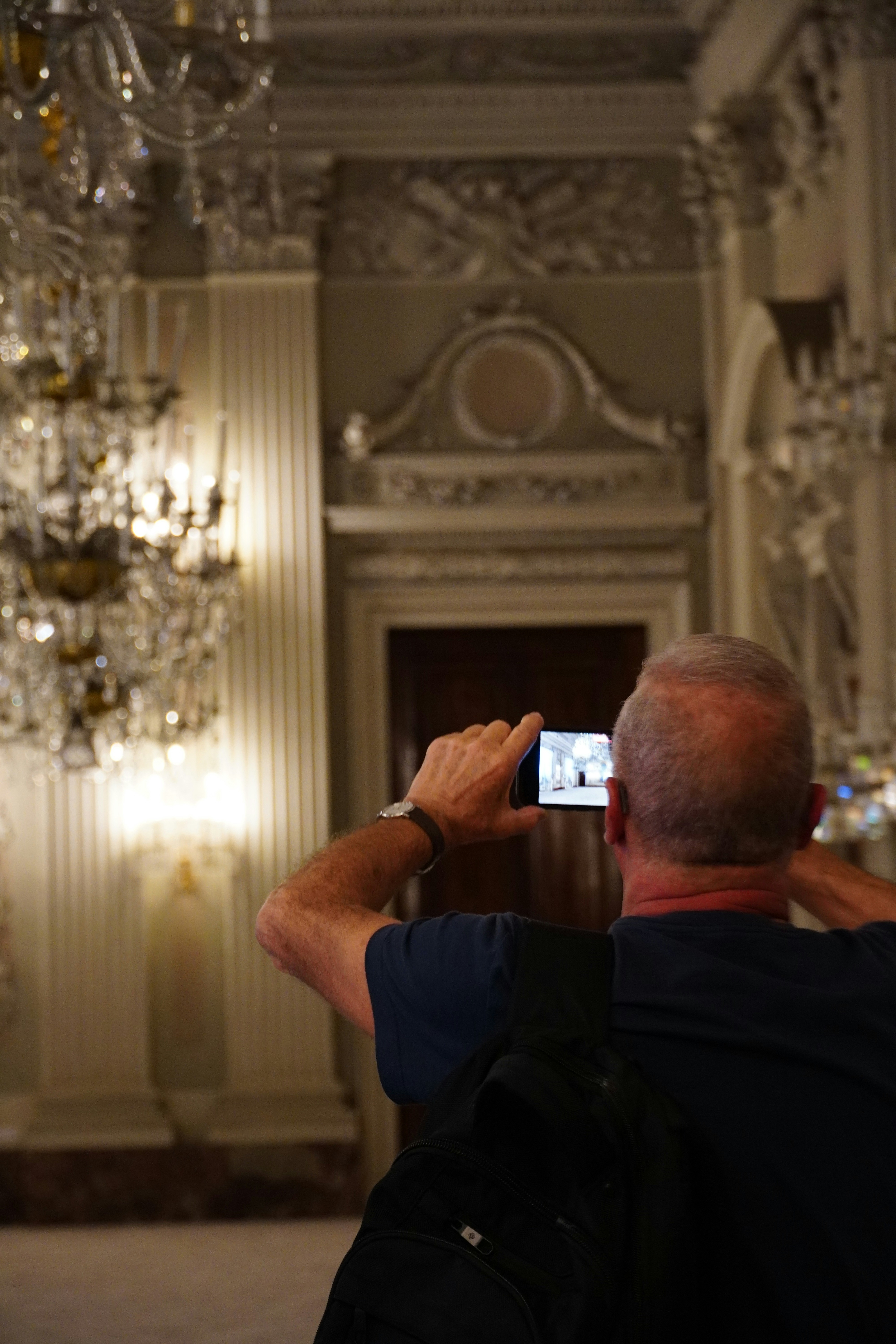 A man taking a picture of a chandelier