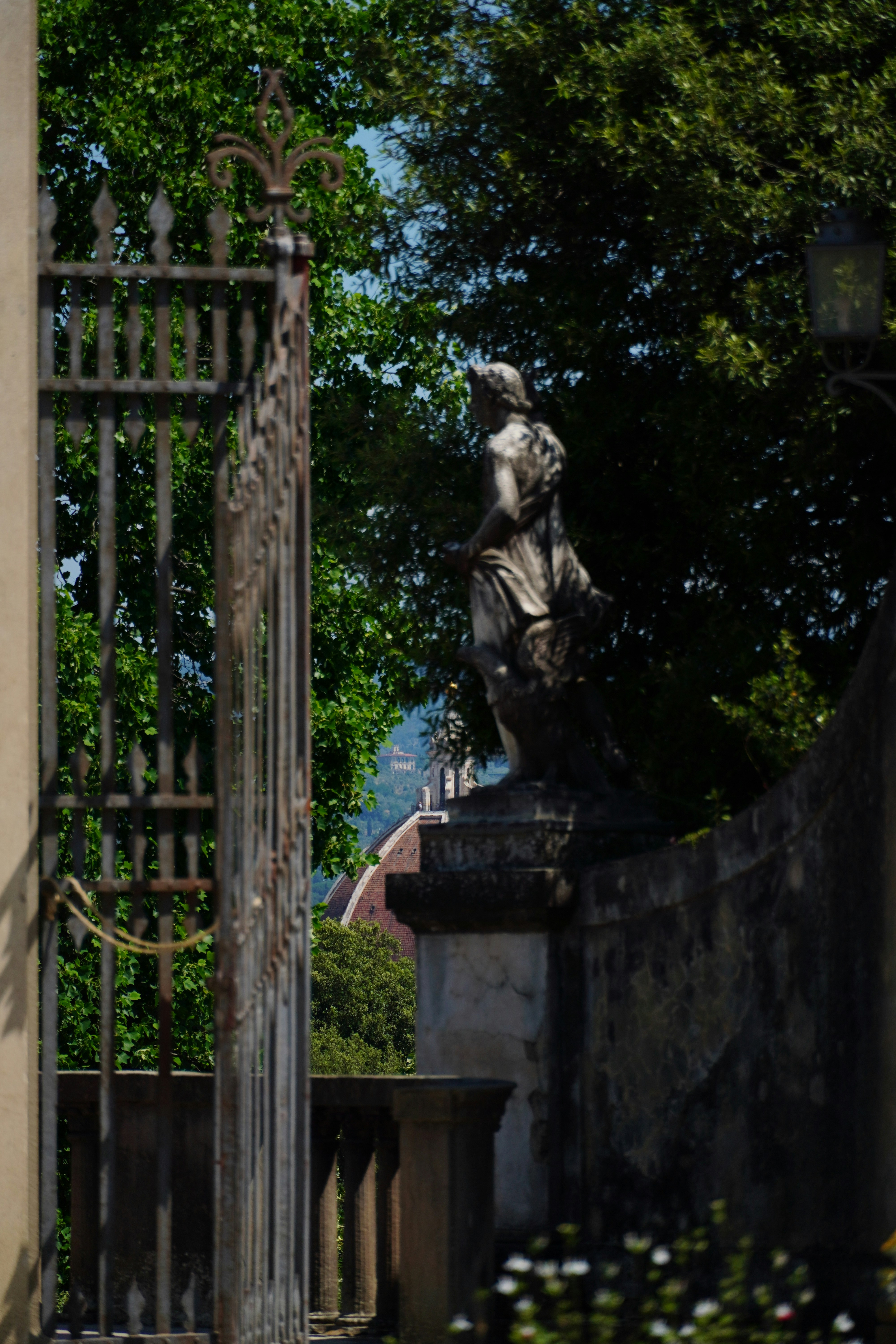 A statue of a woman on a pedestal in front of a gate