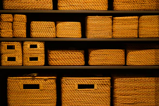 A shelf filled with lots of wicker baskets