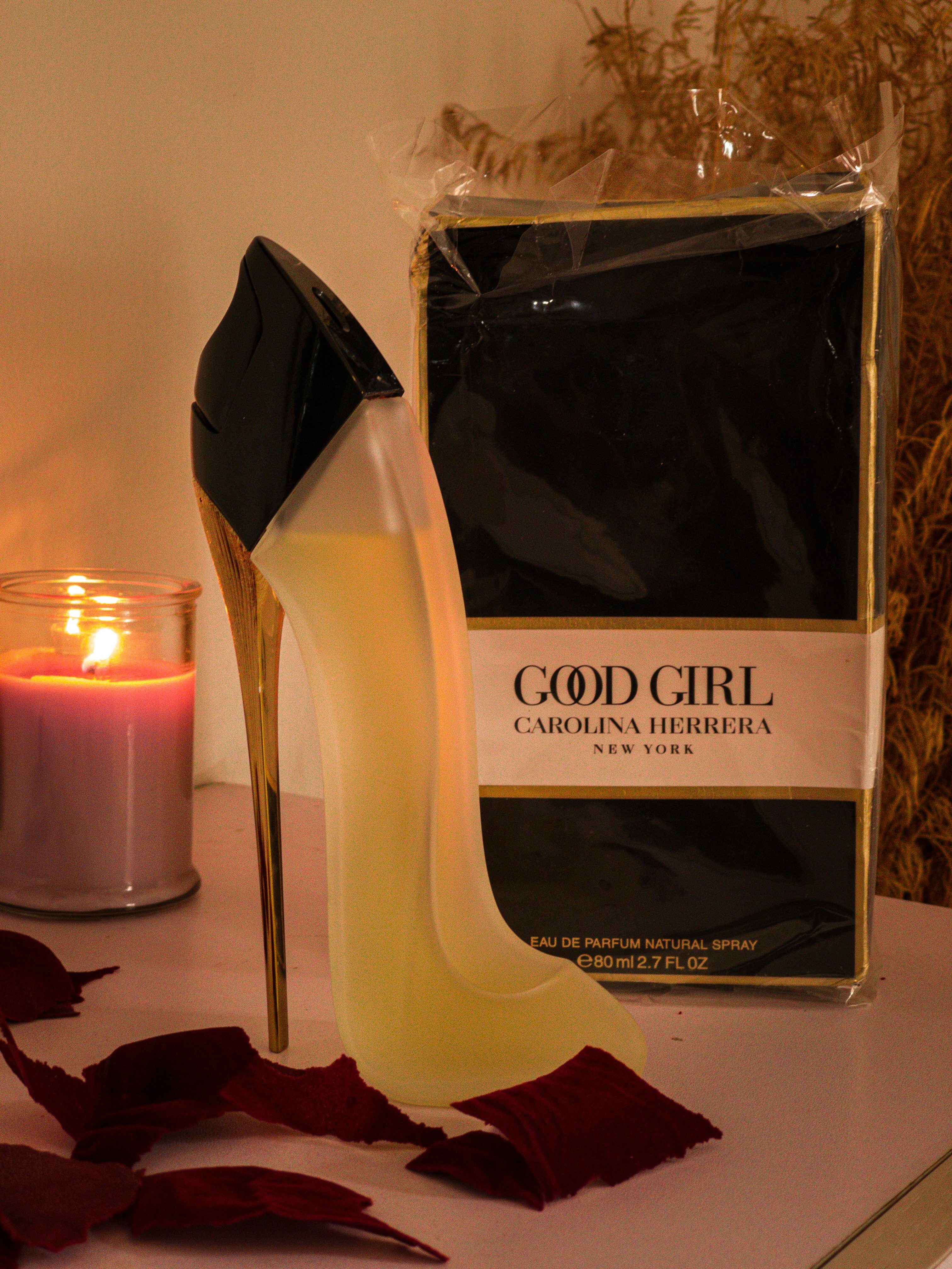 Carolina Herrera Good Girl stiletto heel shaped perfume bottle in black and gold with dramatic lighting