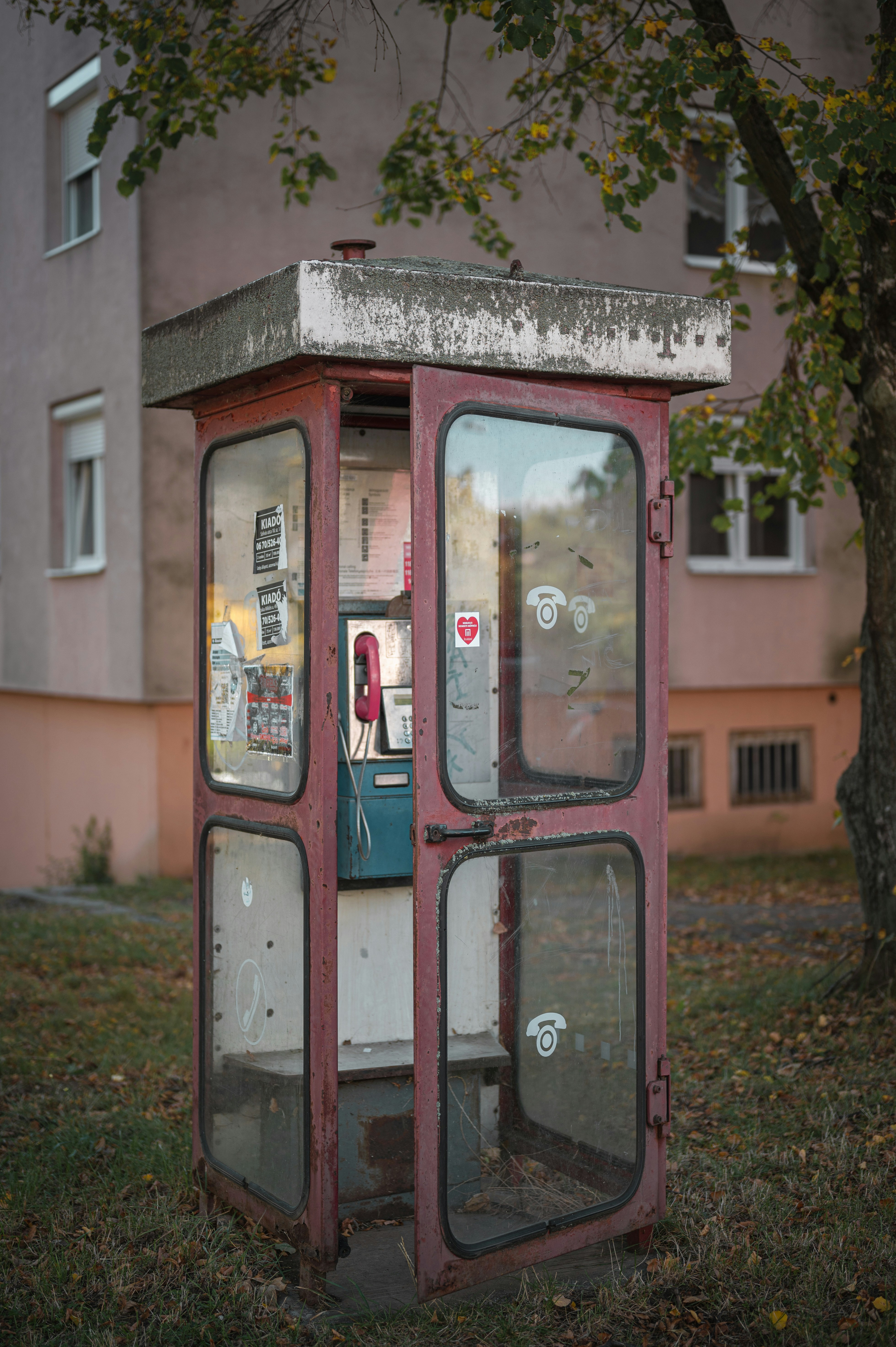 A public phone booth sitting on the side of a road