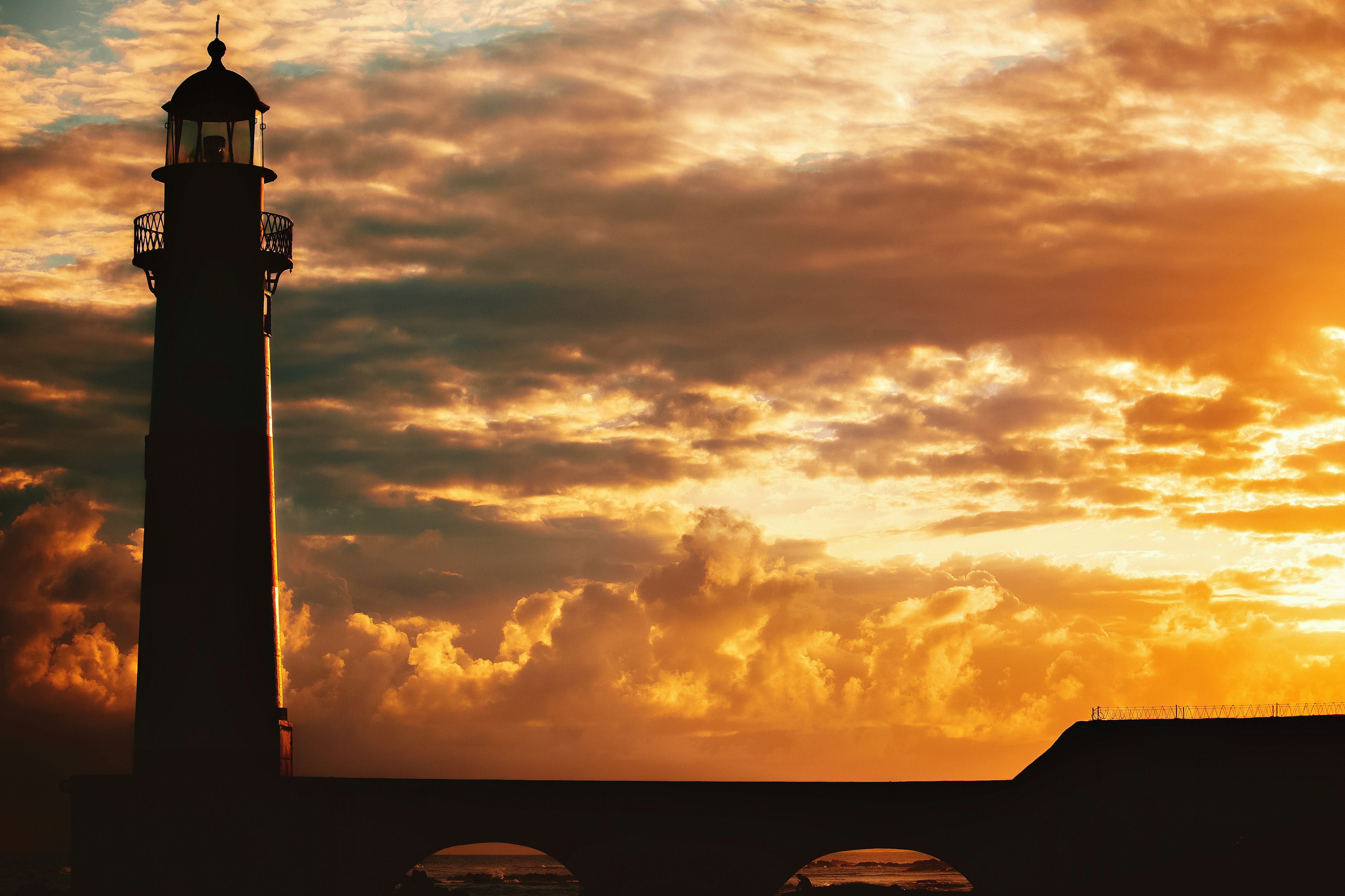 A lighthouse with the sun setting behind it photo – Free Nature Image ...