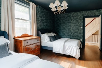 A bedroom with two beds and a dresser