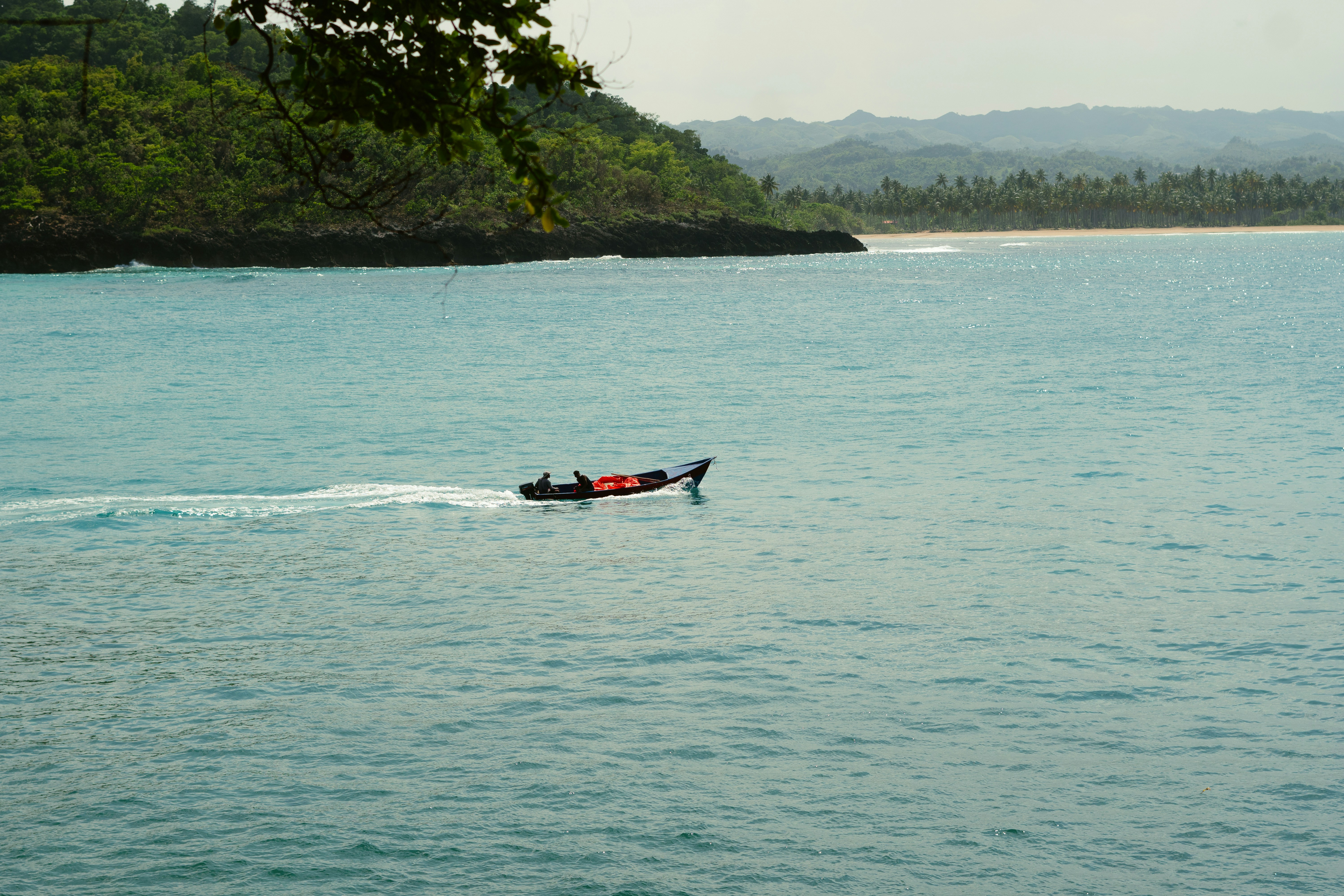 A small boat in the middle of a large body of water