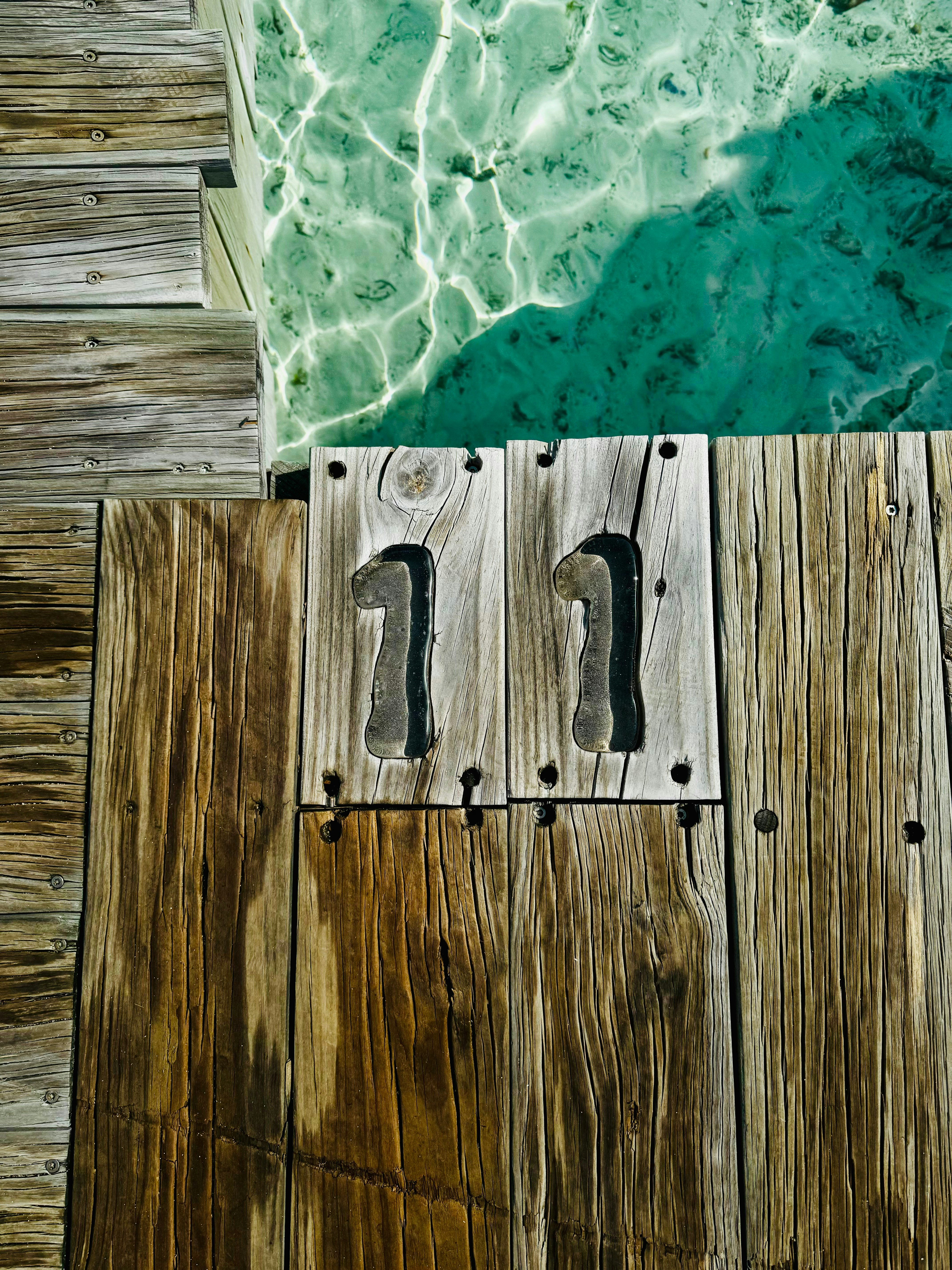 A picture of a wooden dock with a pool in the background
