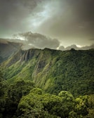 A view of a lush green mountain range under a cloudy sky