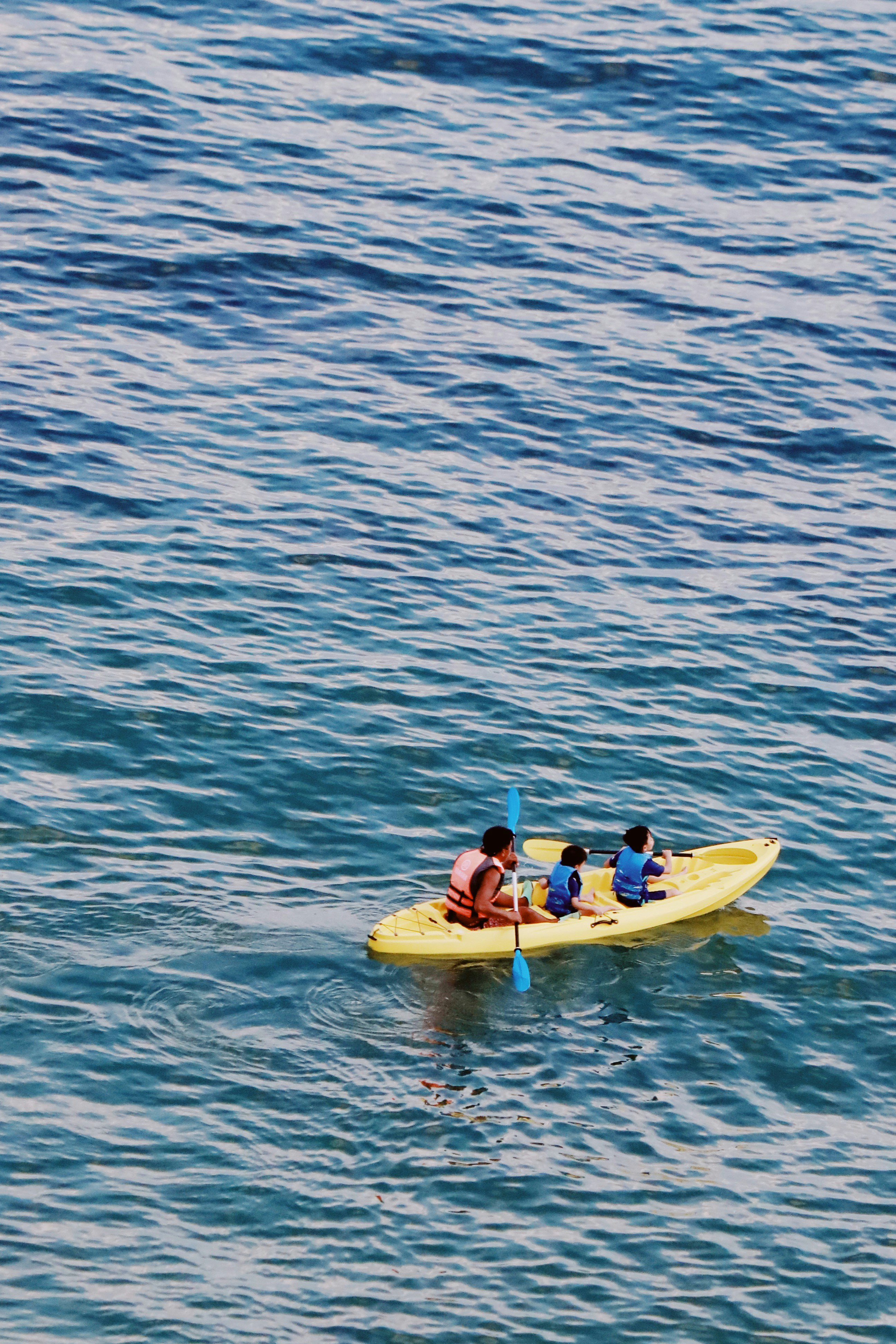 A group of people riding on top of a yellow boat photo – Free Sea Image ...
