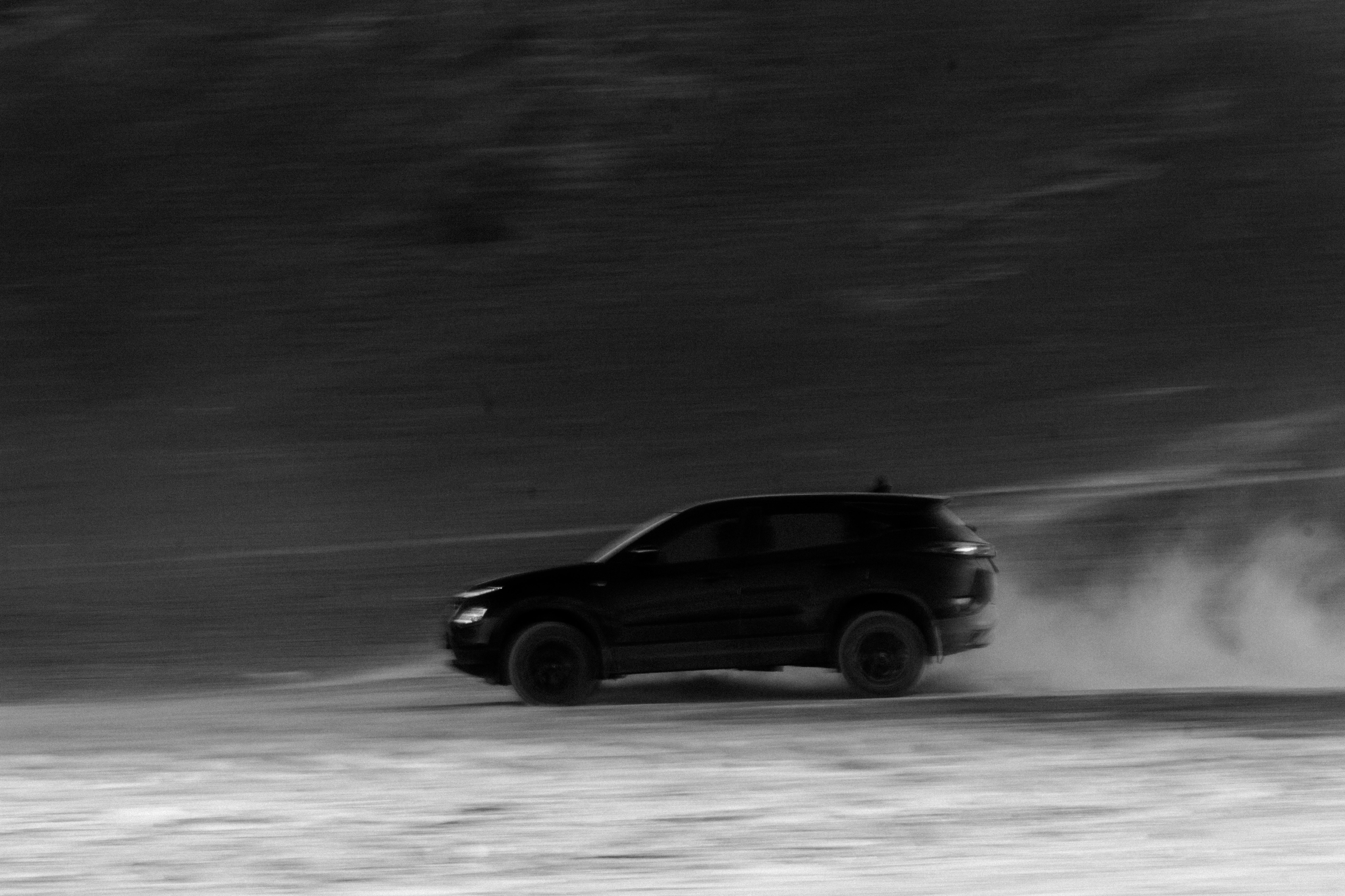 Ein Schwarz-Weiß-Foto eines Lastwagens, der durch die Wüste fährt