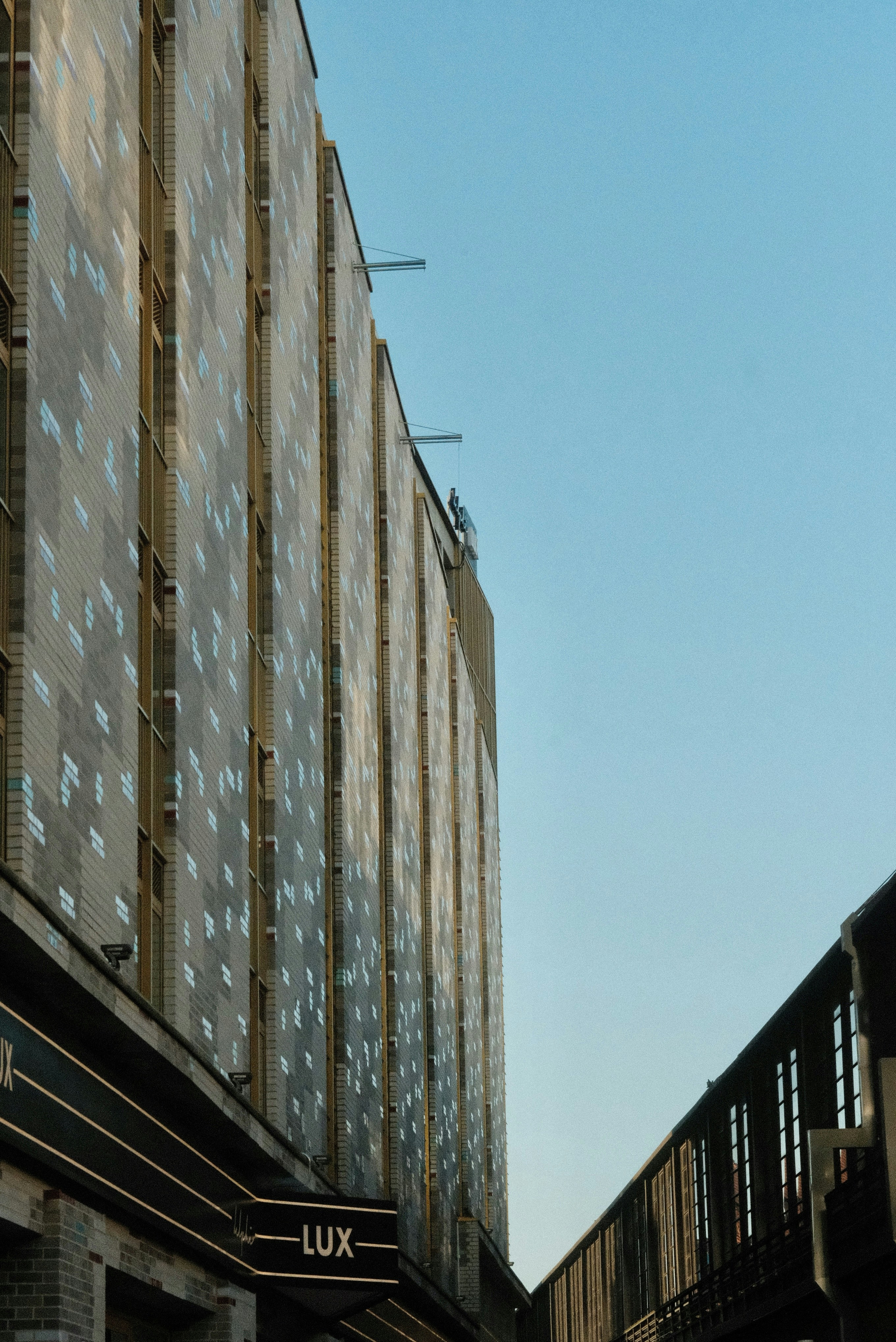 A train traveling down tracks next to a tall building