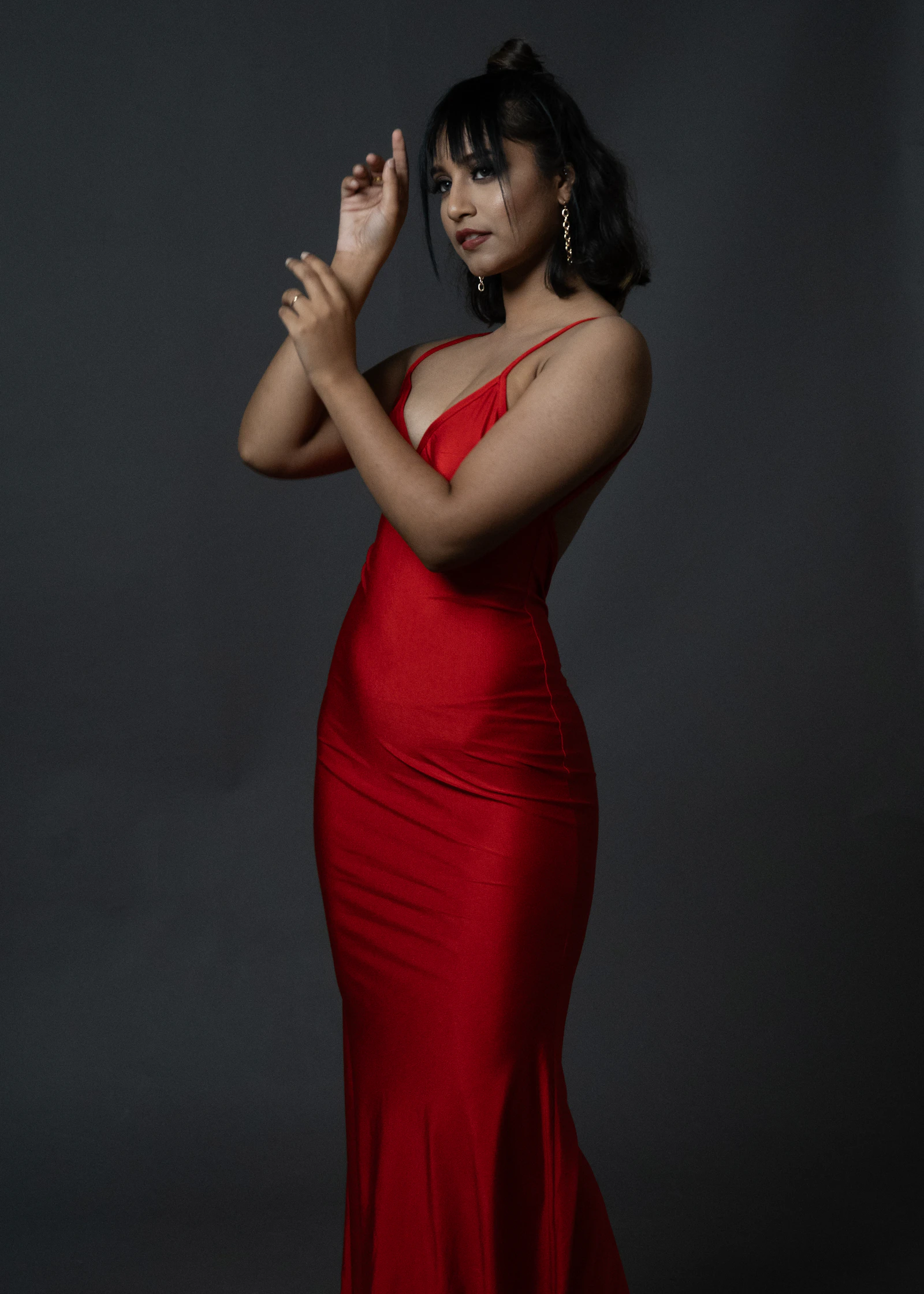 Woman posing in a fitted red evening dress