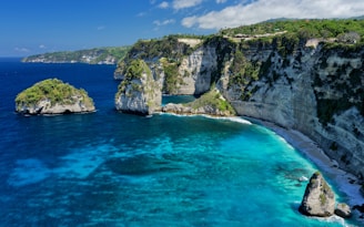 An aerial view of a beach with blue water