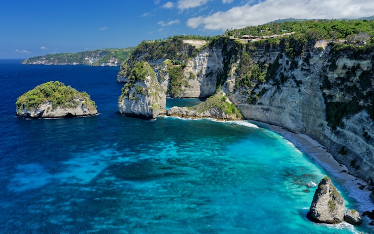 An aerial view of a beach with blue water