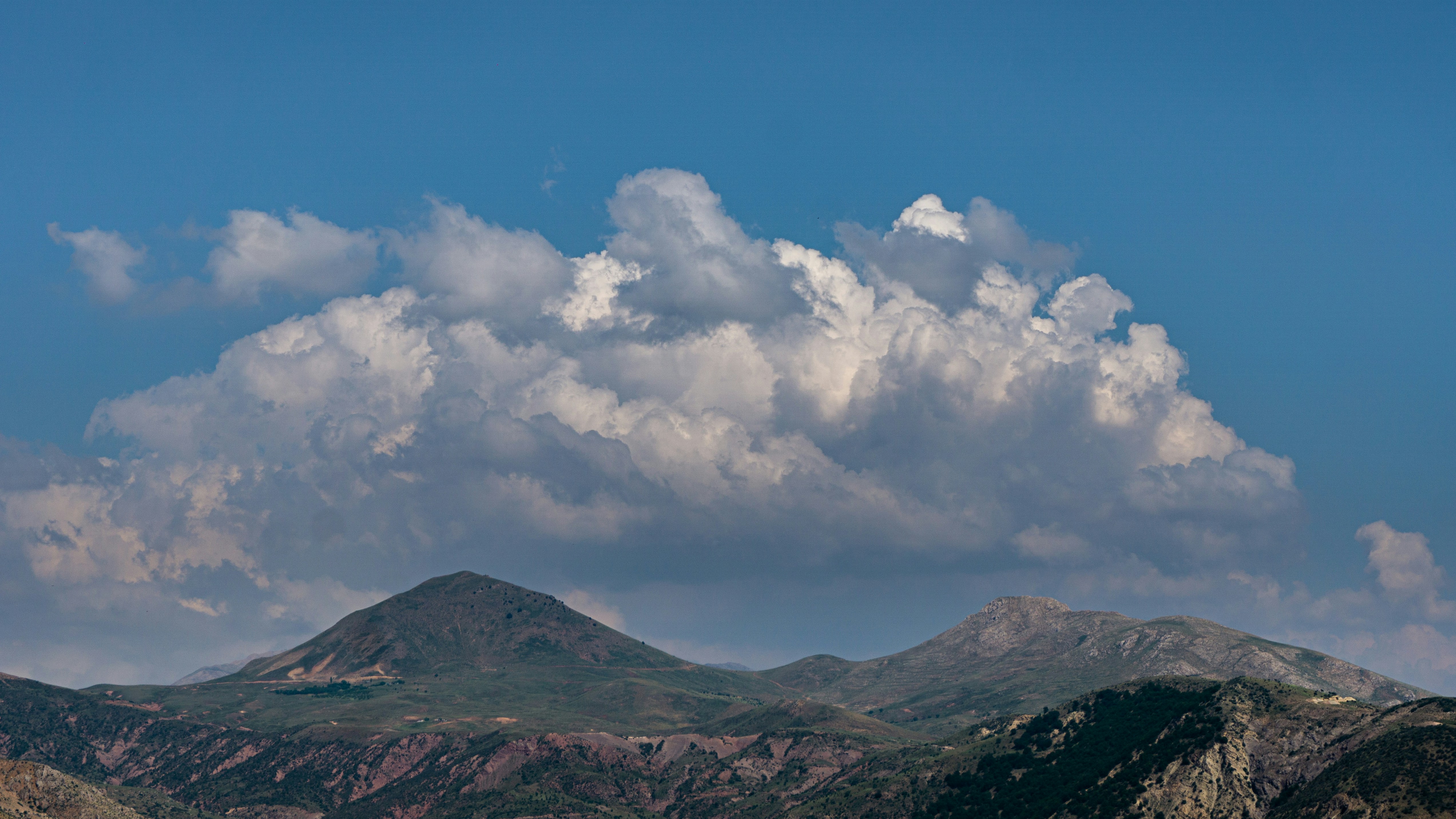 Una vista de una cadena montañosa con nubes en el cielo