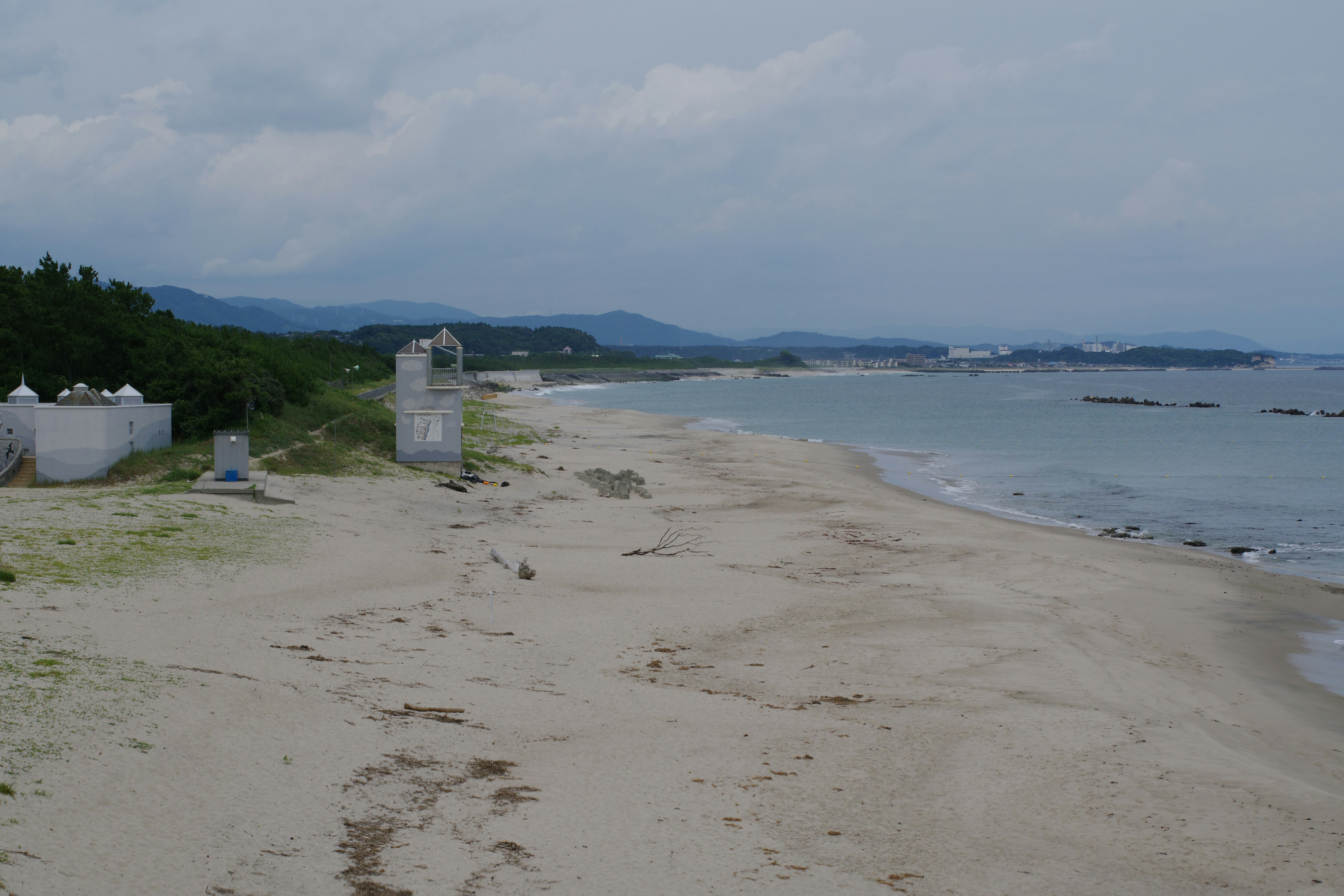 A sandy beach next to the ocean under a cloudy sky