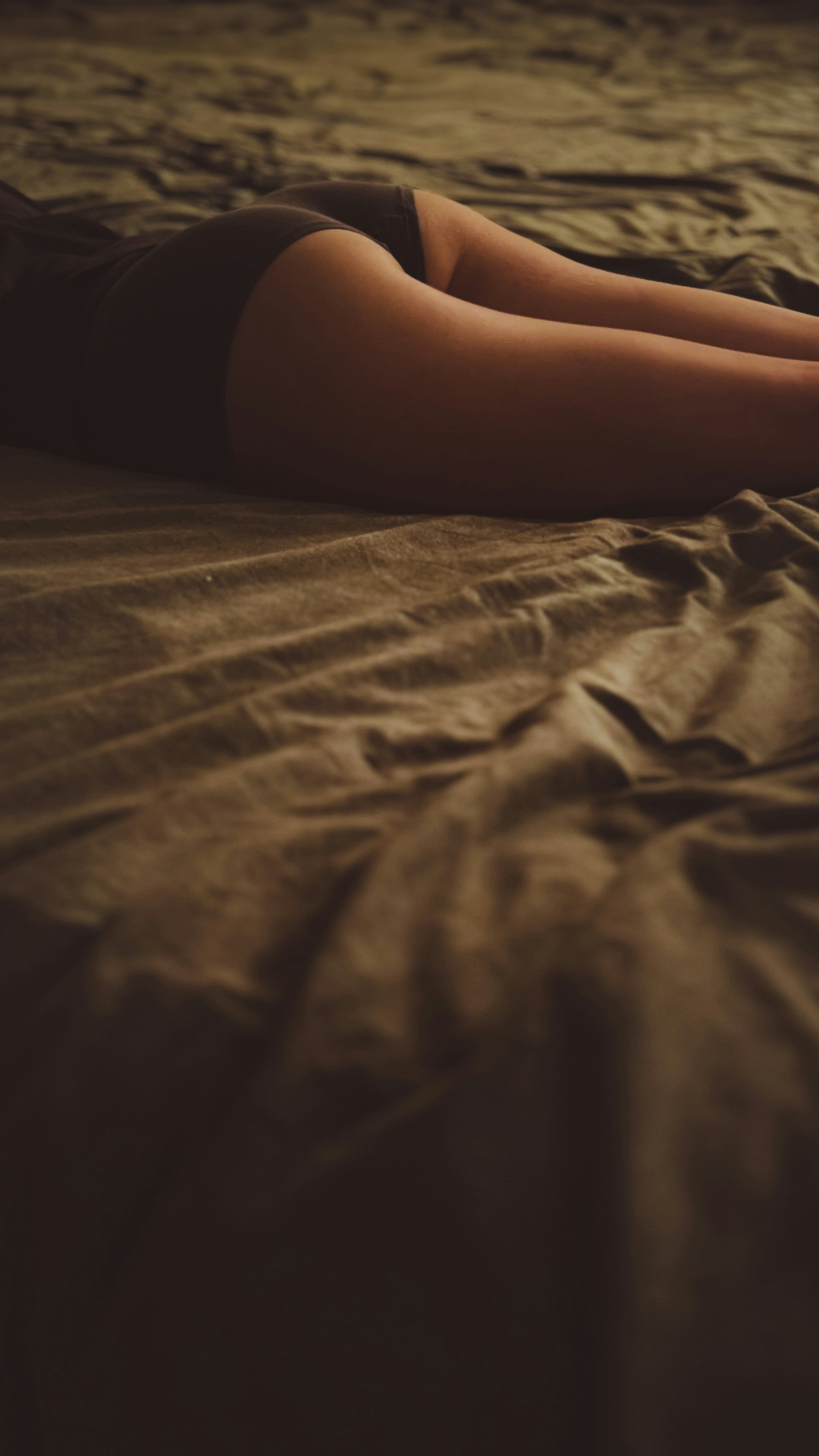 A woman laying on a bed with her legs crossed