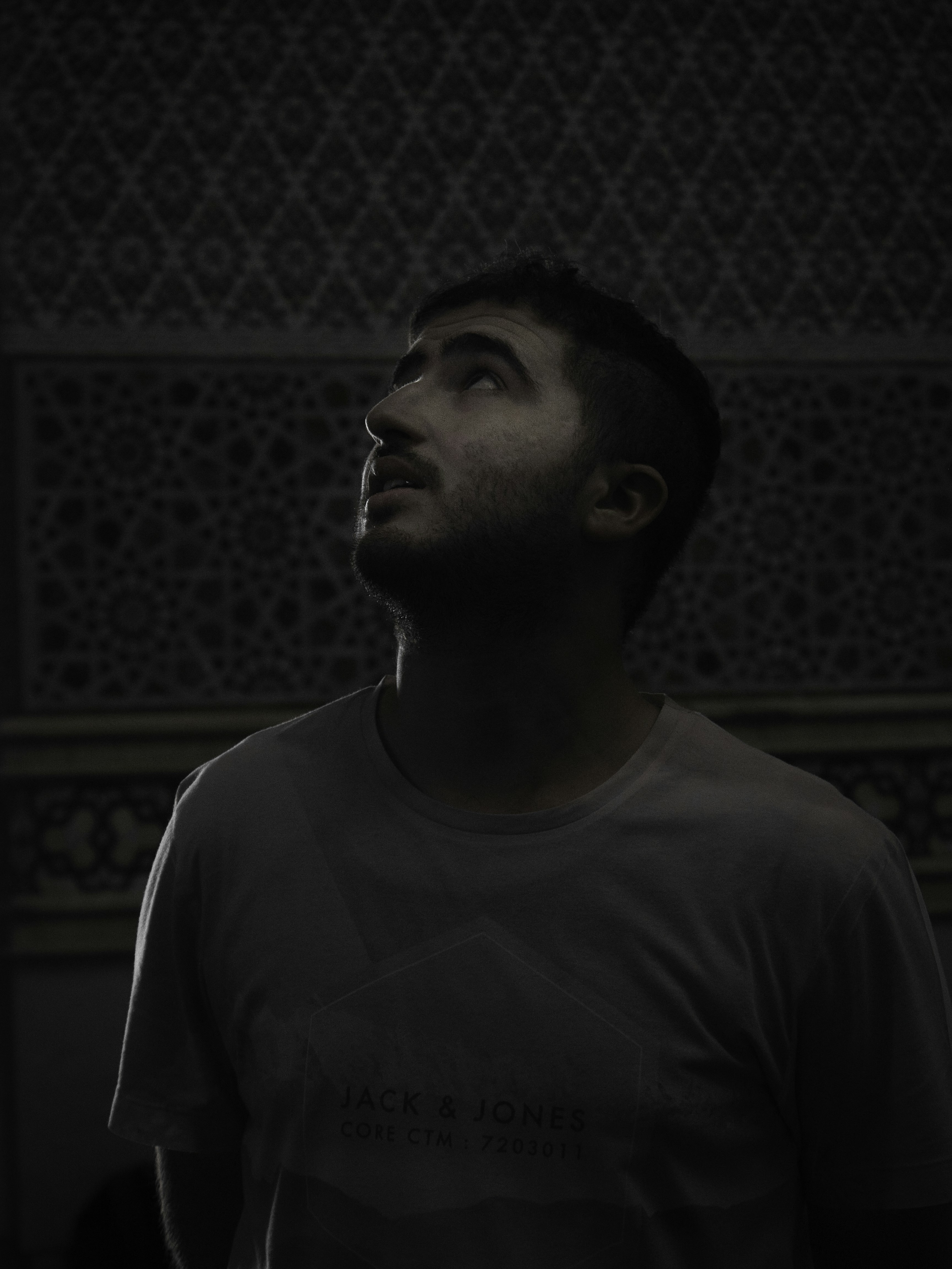 A man standing in a dark room looking up