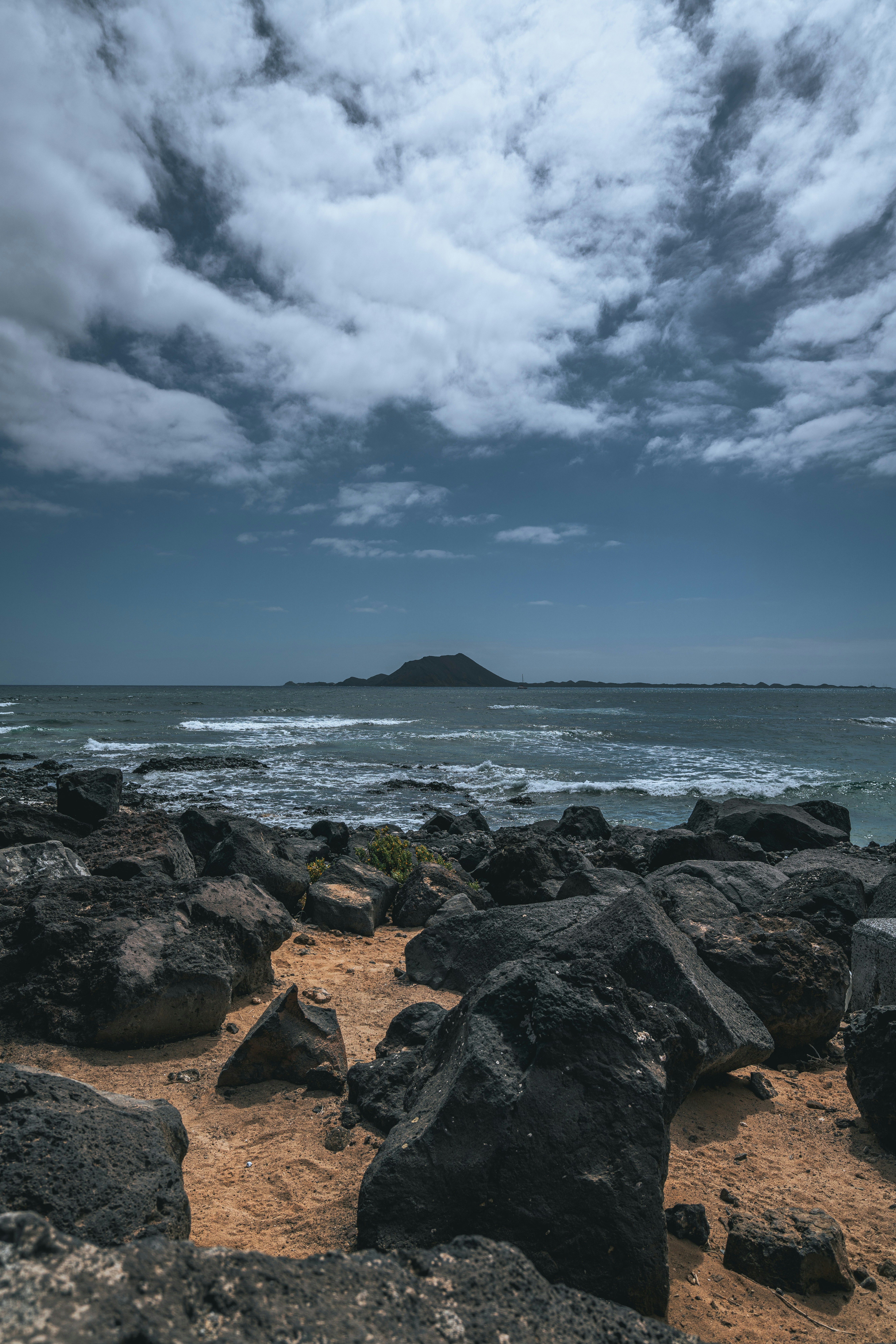 Una spiaggia con rocce e acqua sotto un cielo nuvoloso