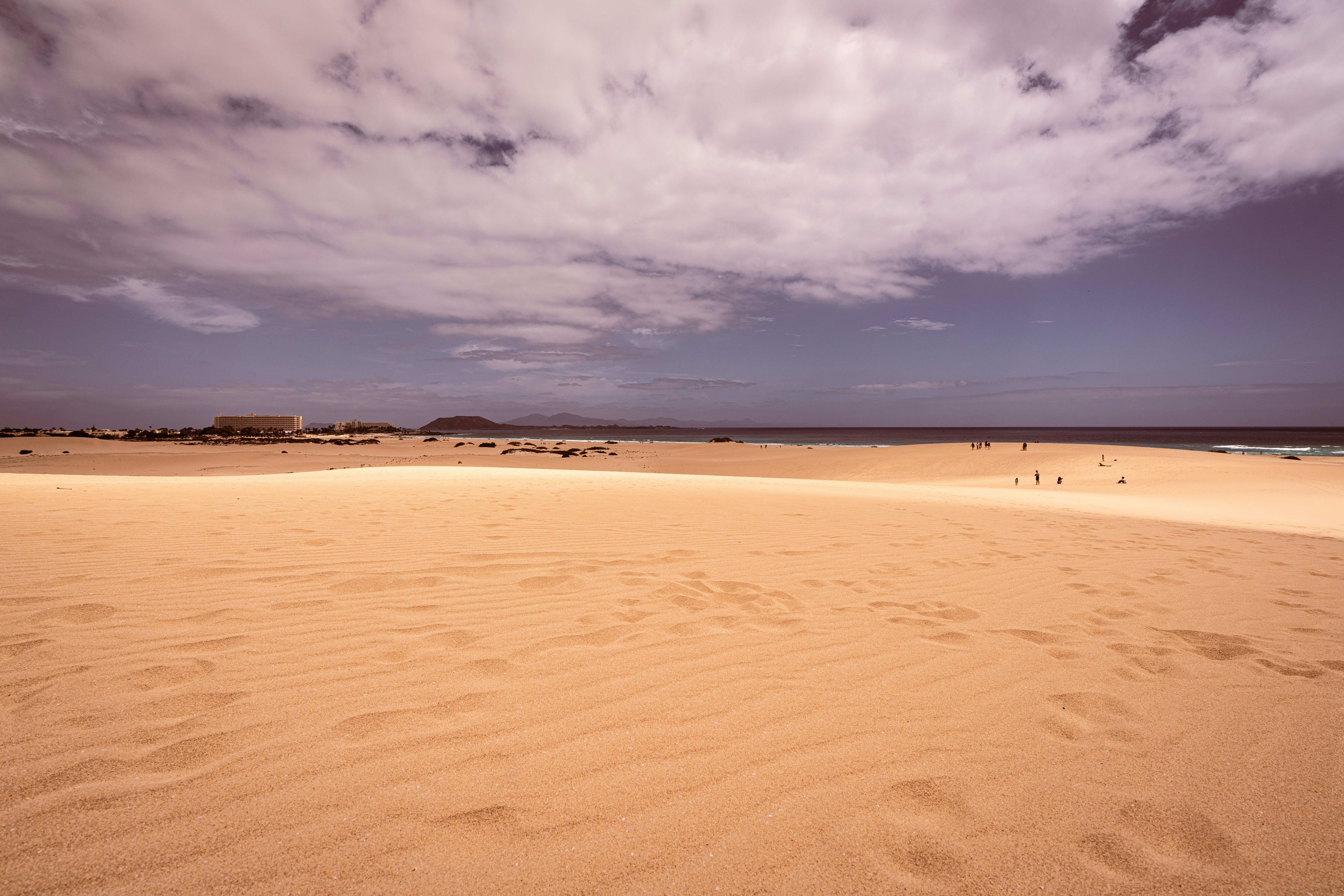 A sandy beach under a cloudy blue sky