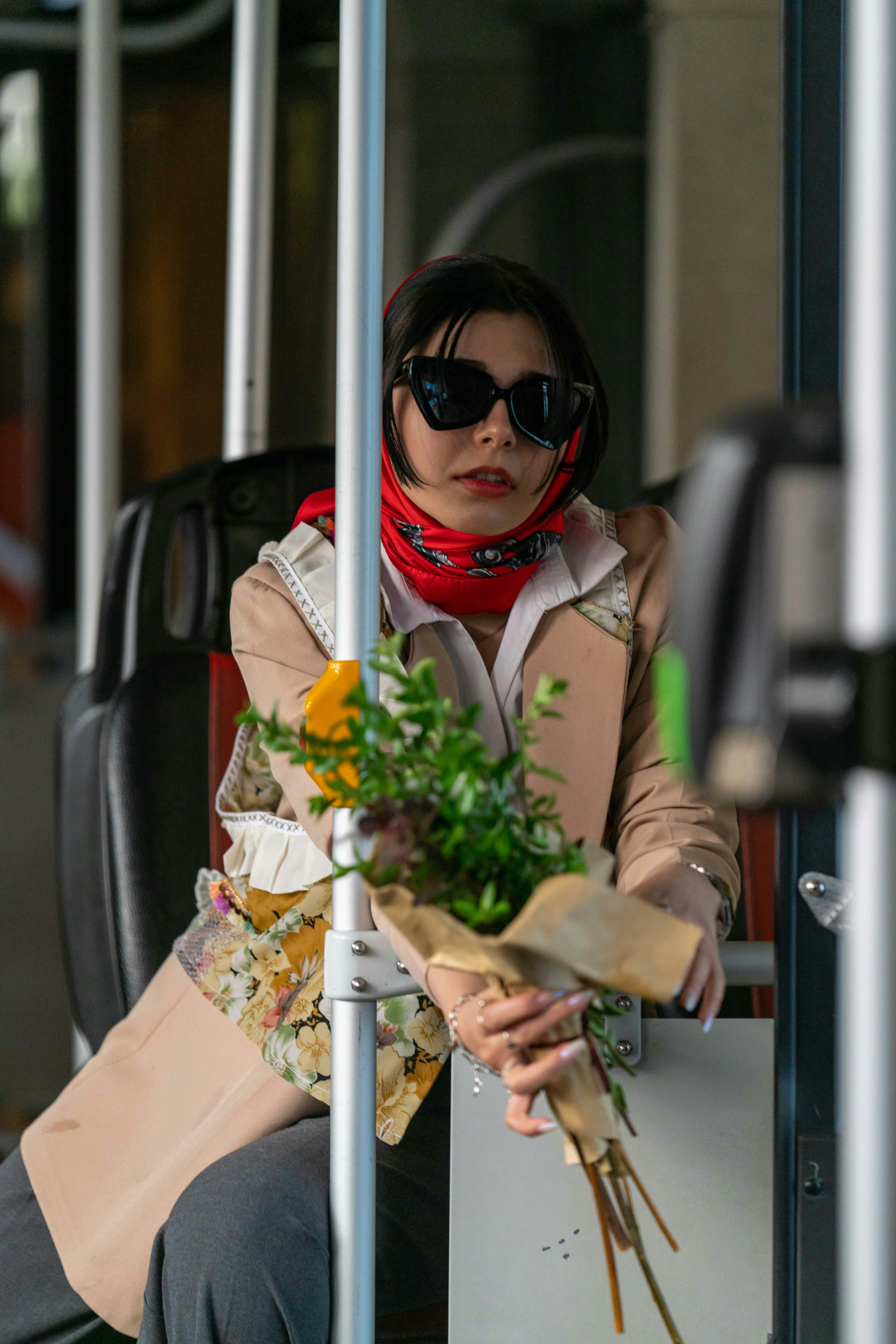 Une femme assise dans un bus tenant un bouquet de fleurs