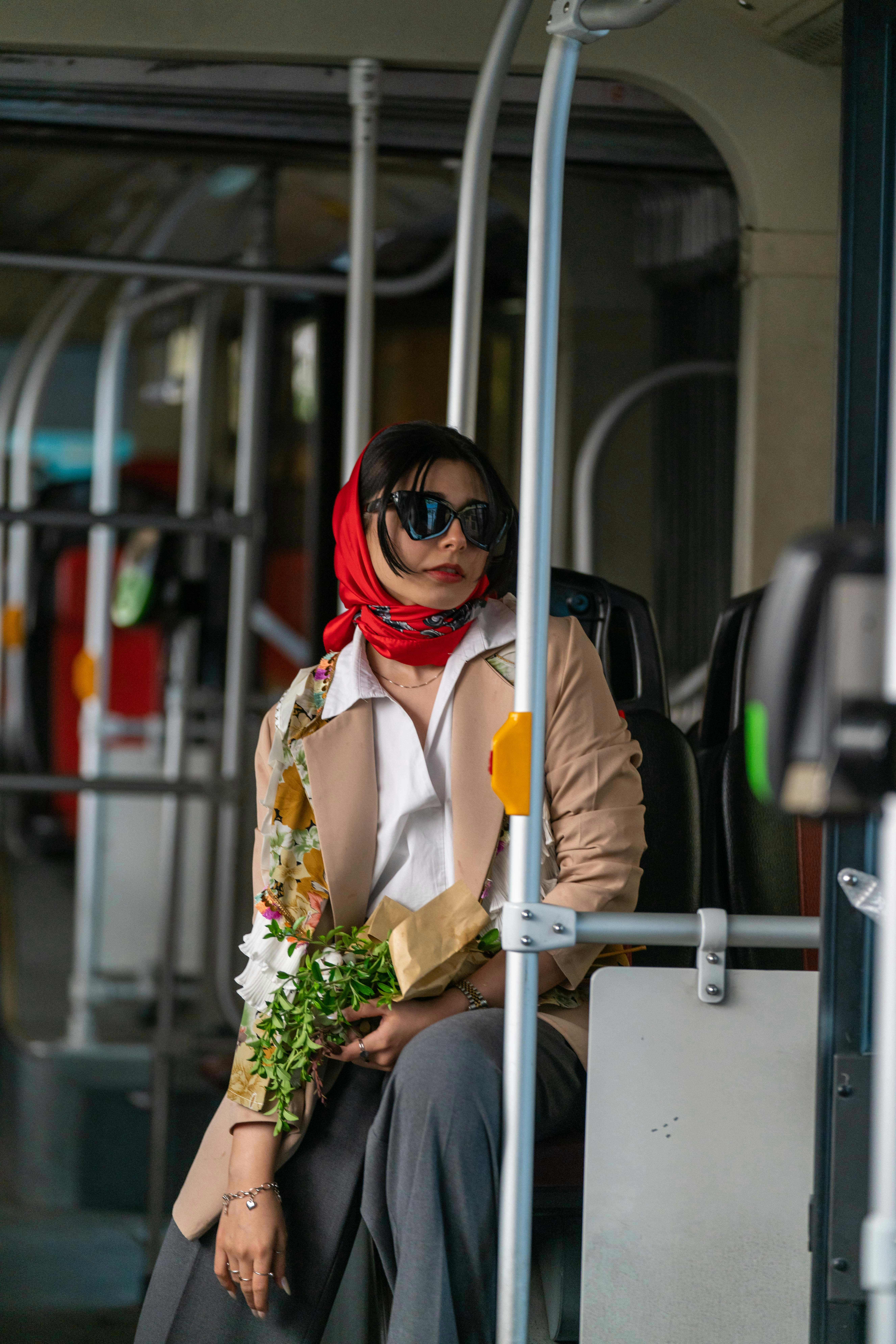 Une femme assise dans un bus tenant des fleurs