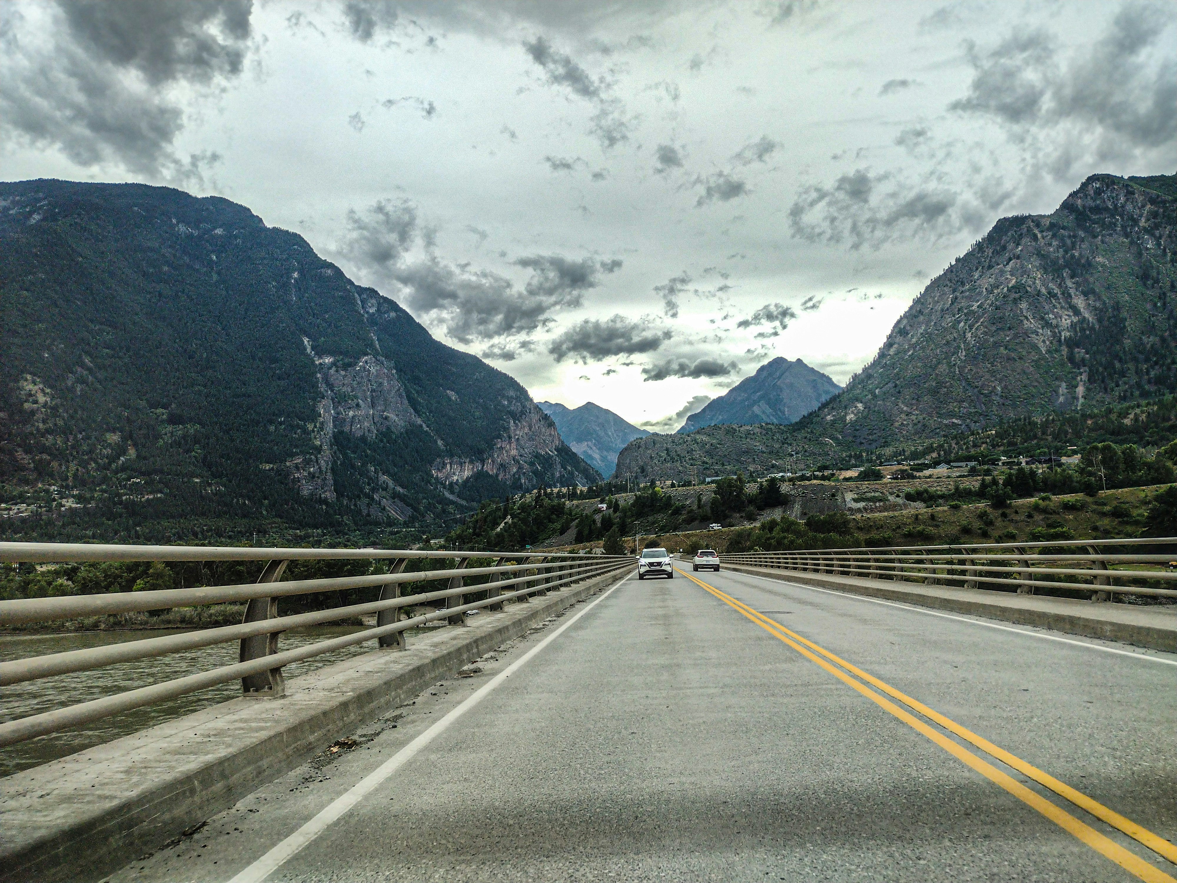 A car driving down a highway with mountains in the background