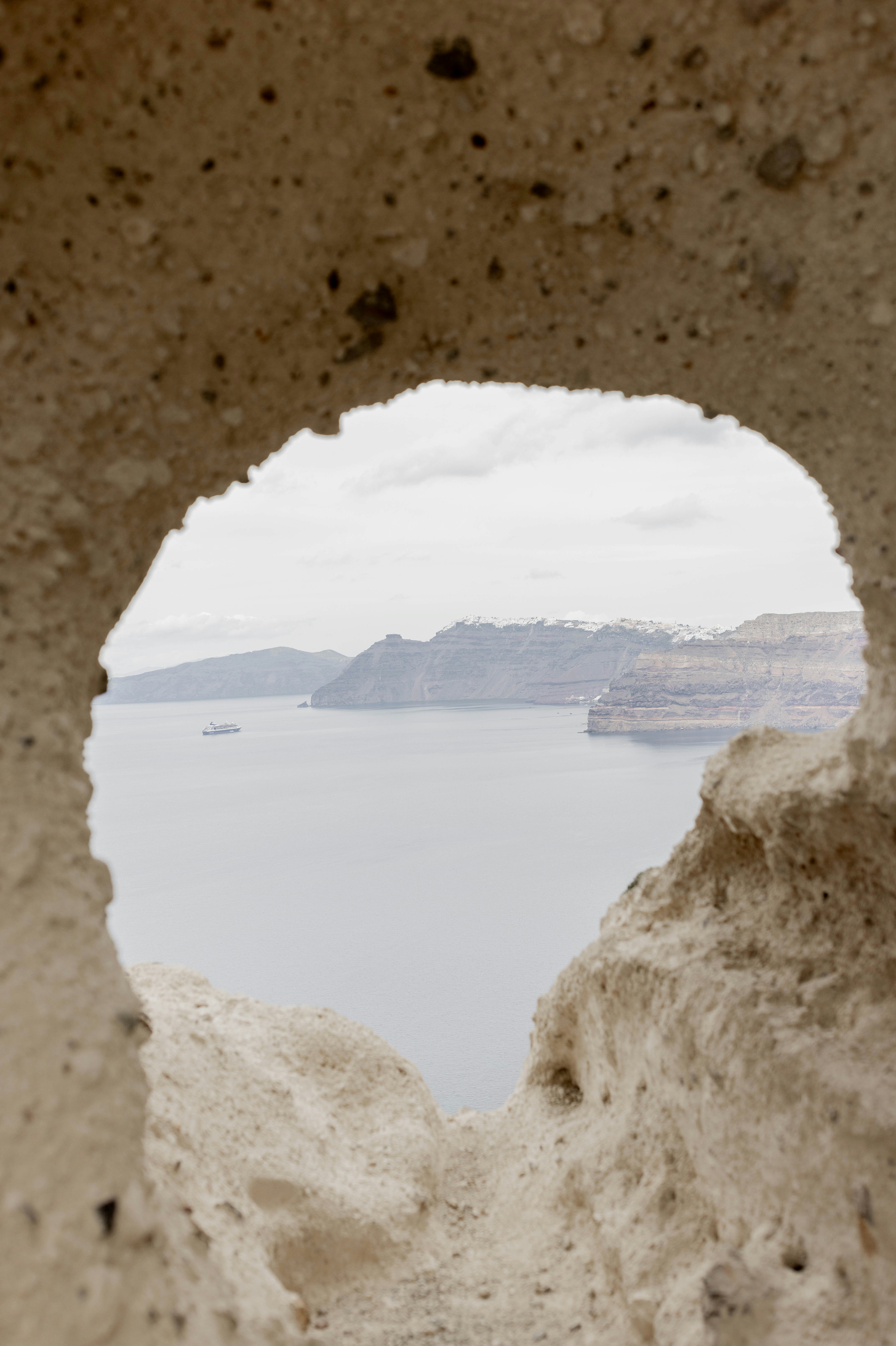 A view of a body of water through a hole in a rock